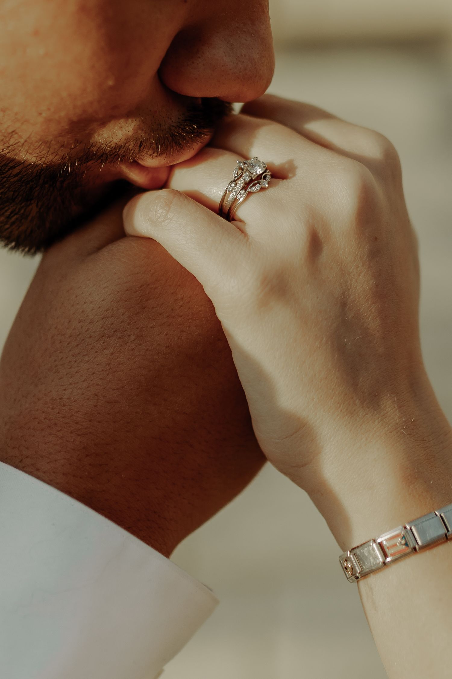 man kissing girls engagement ring hand during engagement photoshoot in downtown grand junction  colorado photoshoot