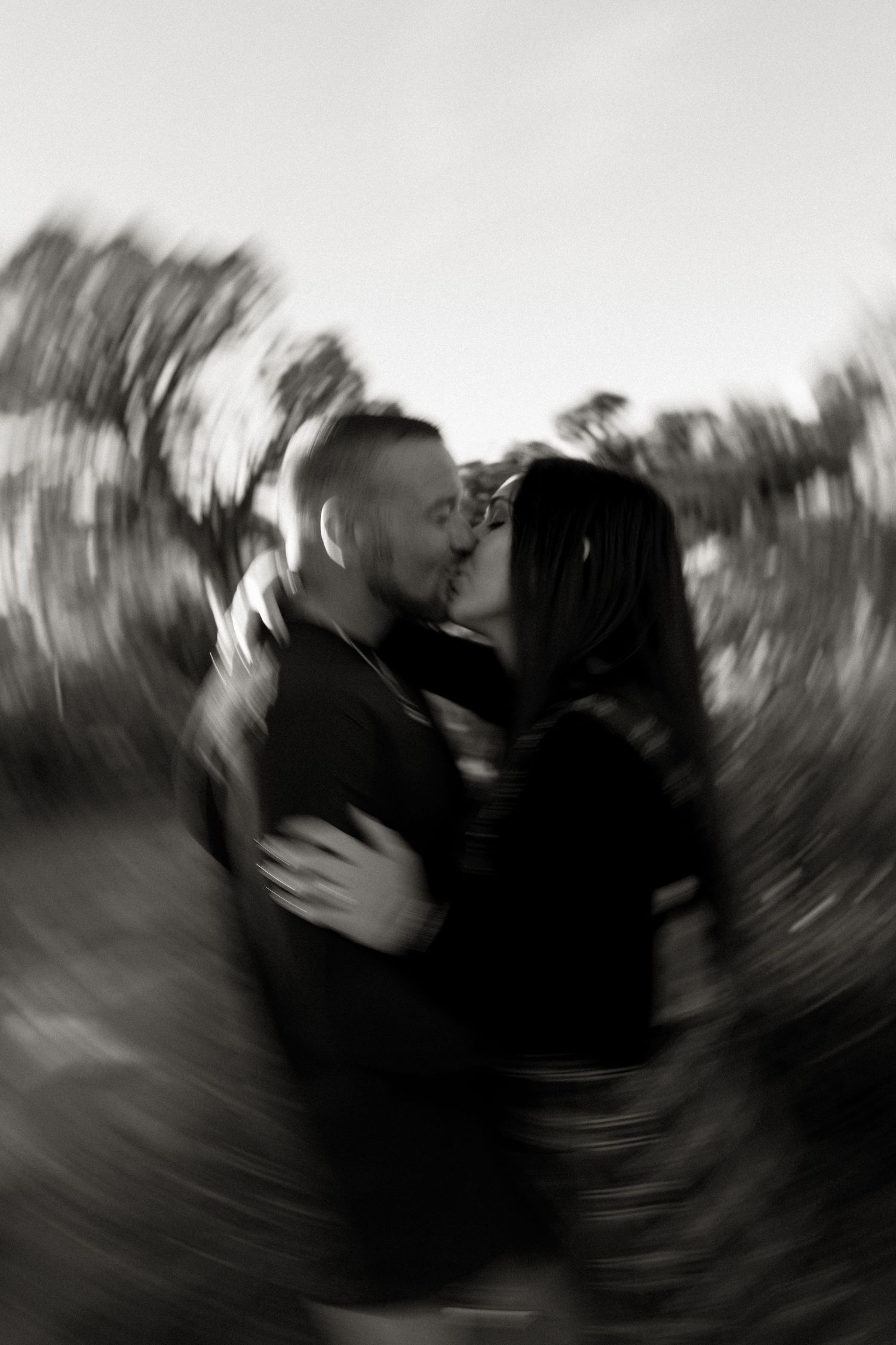 blurry black and white photography of couple kissing during engagement photoshoot on colorado national monument