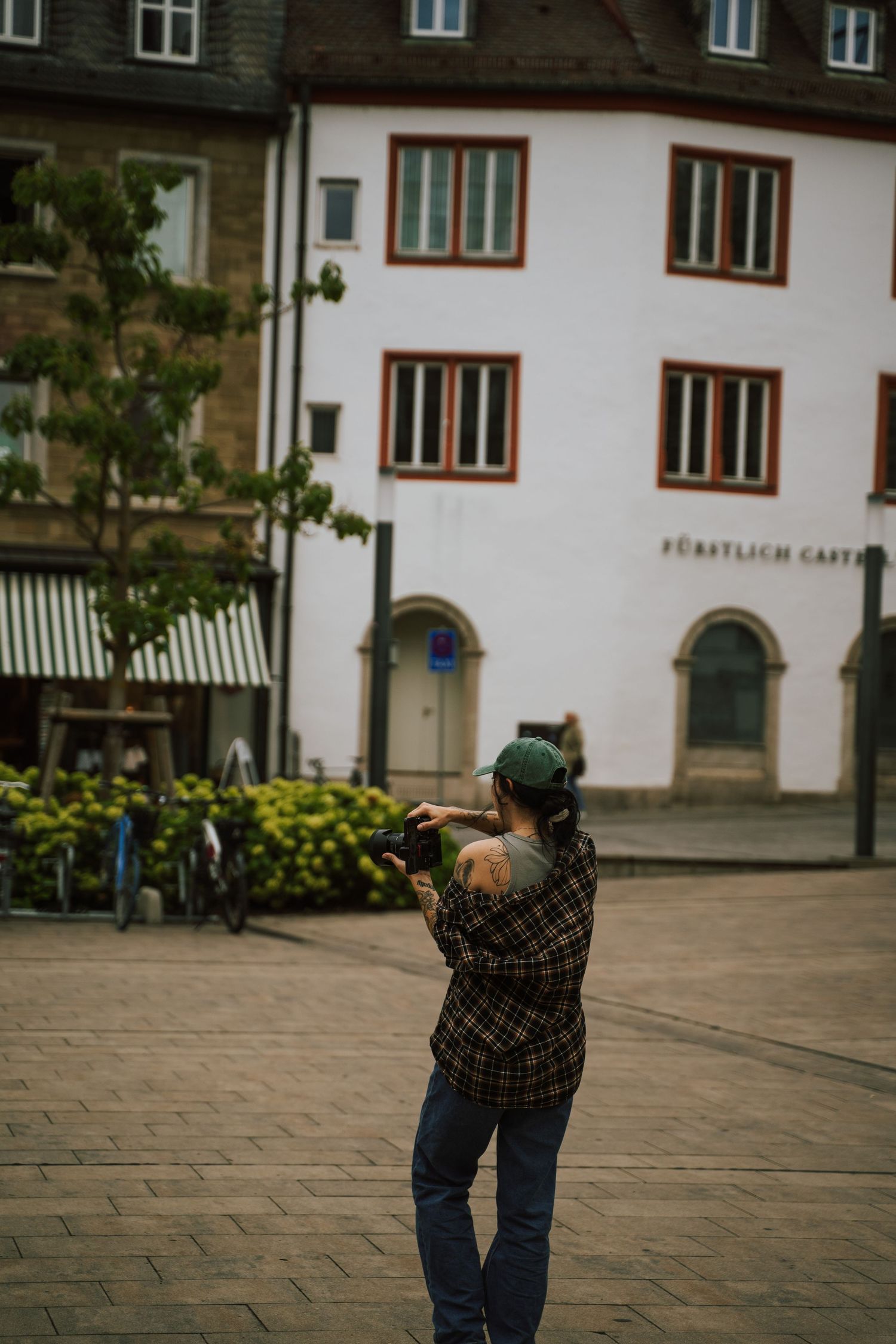 Photographer taking pictures in front of a traditional European building facade.
