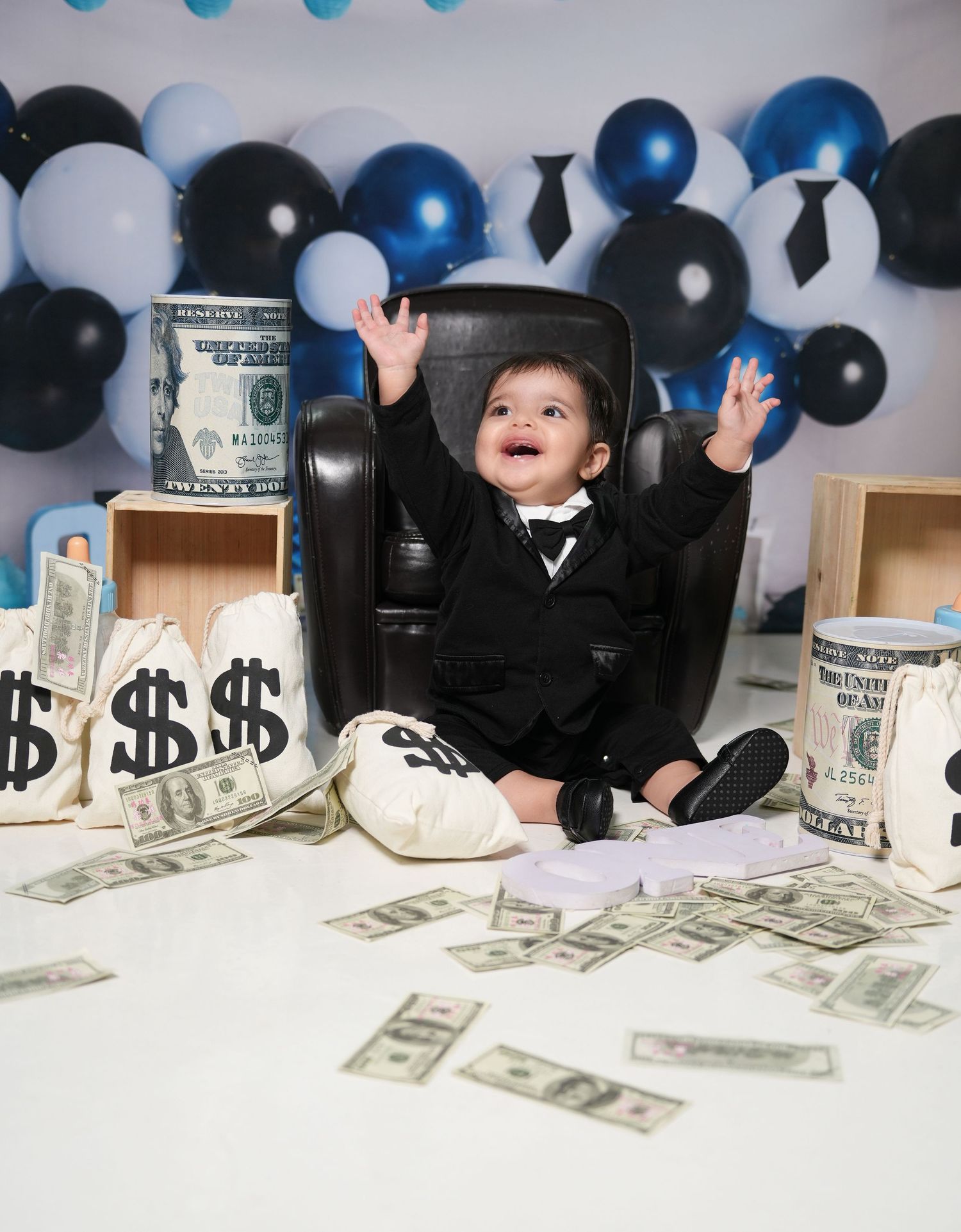 Money rolls and black balloons create a dramatic party scene with cash scattered on a white surface.