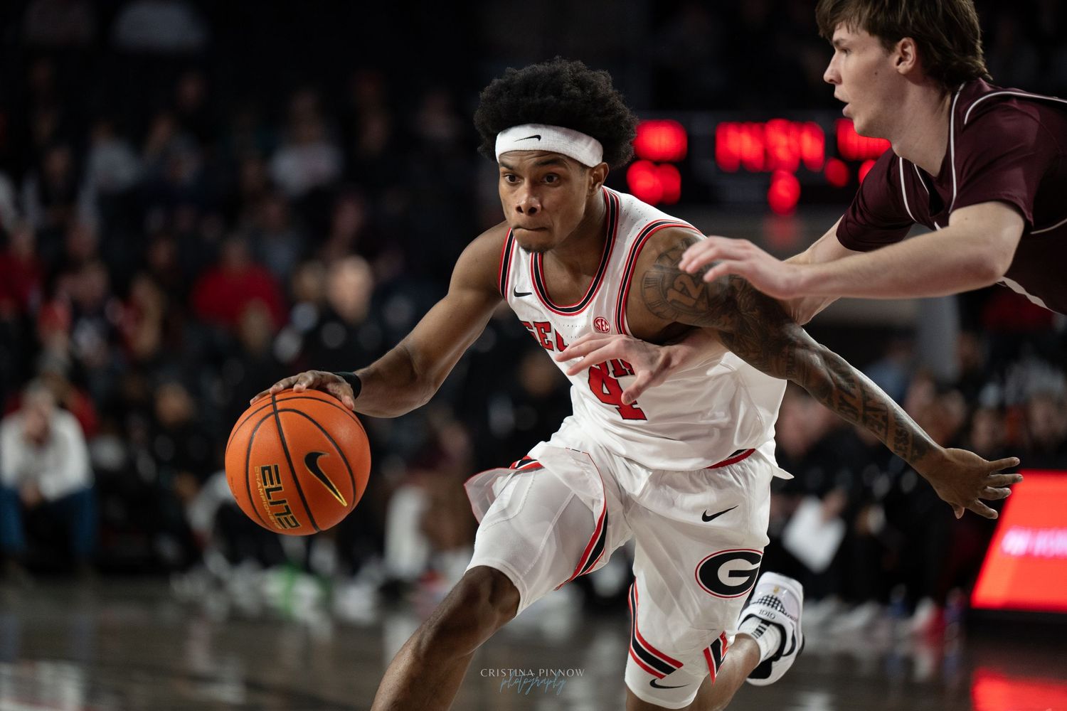Basketball players in white and red uniforms compete during a game.
