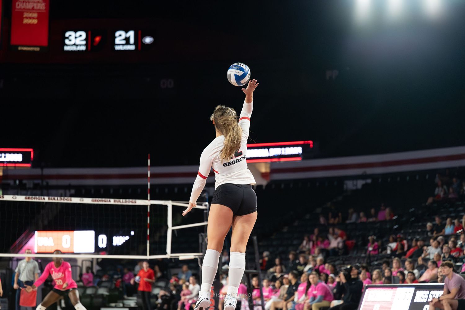Volleyball match in progress with players positioned for action.