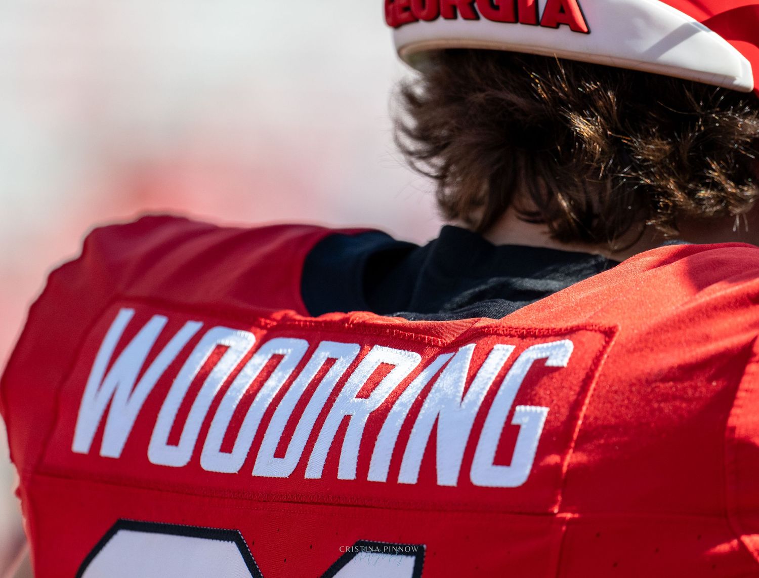 Red sports jerseys with white lettering displayed in a row.