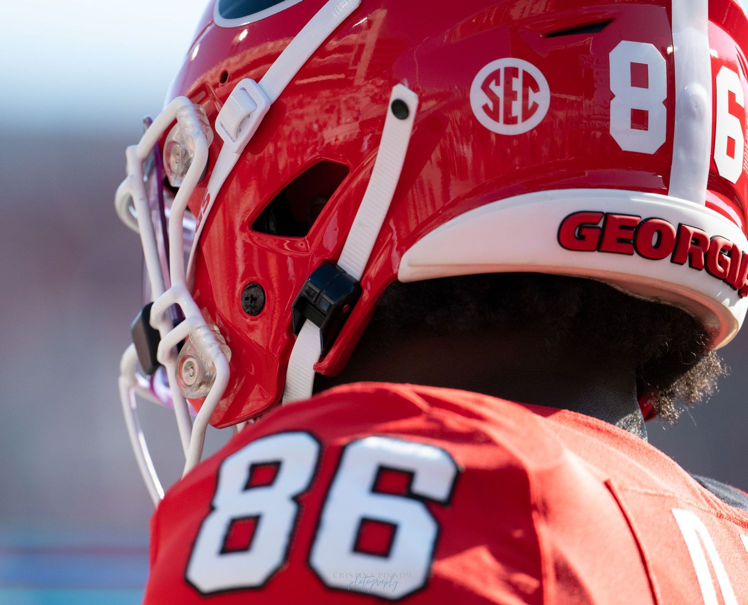 Close-up detail of red football helmet with SEC conference branding.