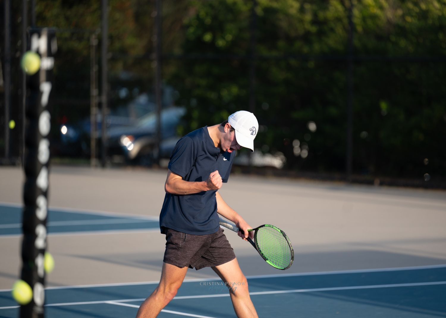 Tennis player executing a powerful backhand shot on an outdoor court during a match.