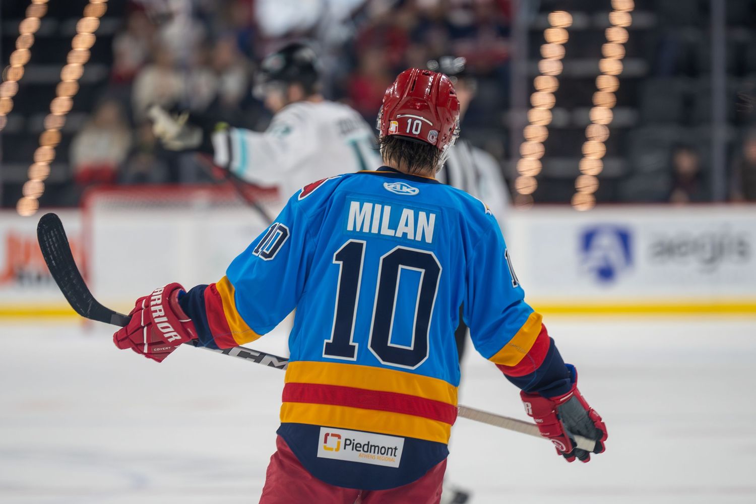 Hockey players in red and blue jerseys compete for the puck during an intense game on the ice.