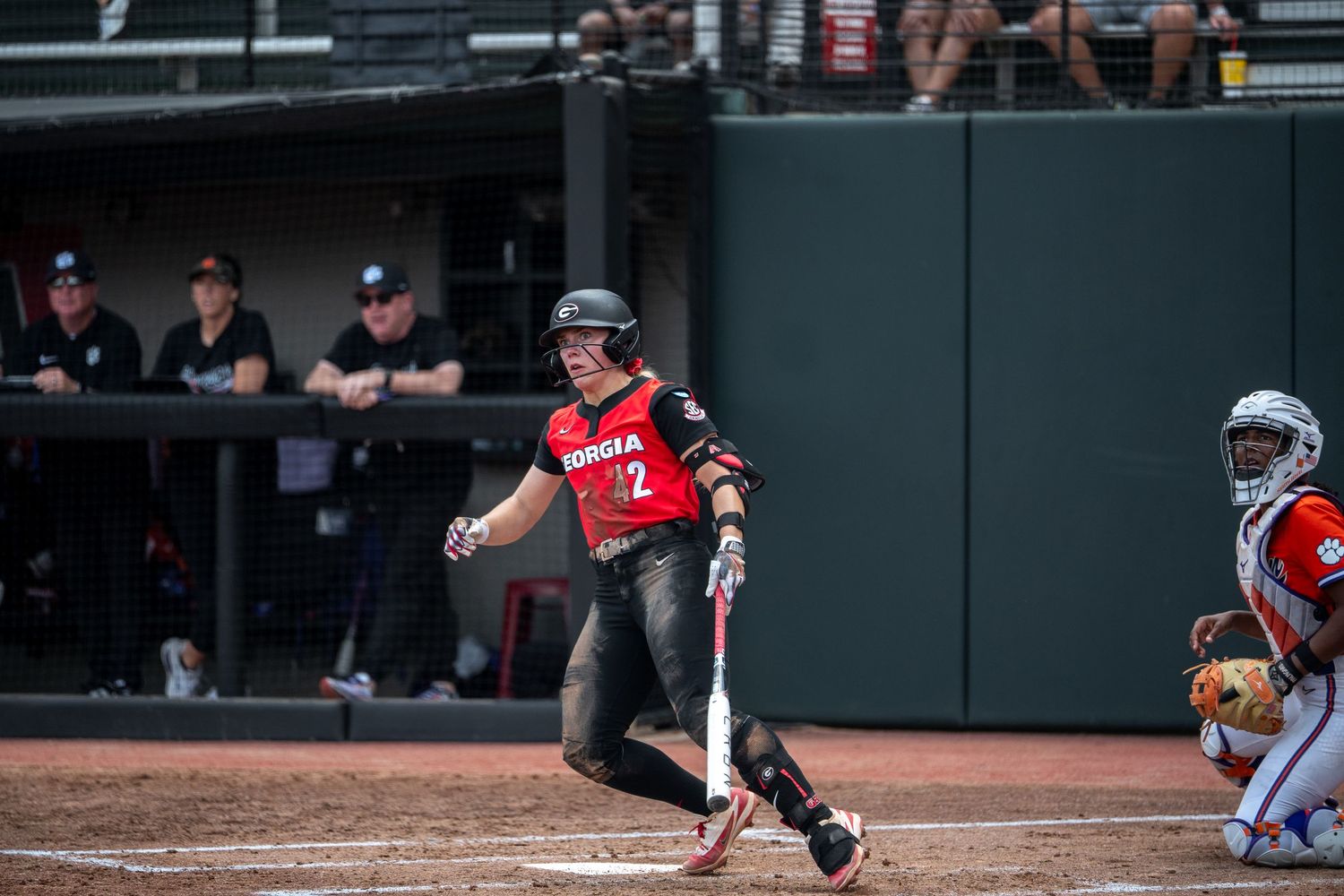 Georgia Bulldogs softball player #2 swings the bat during a competitive game with teammates watching from the dugout.