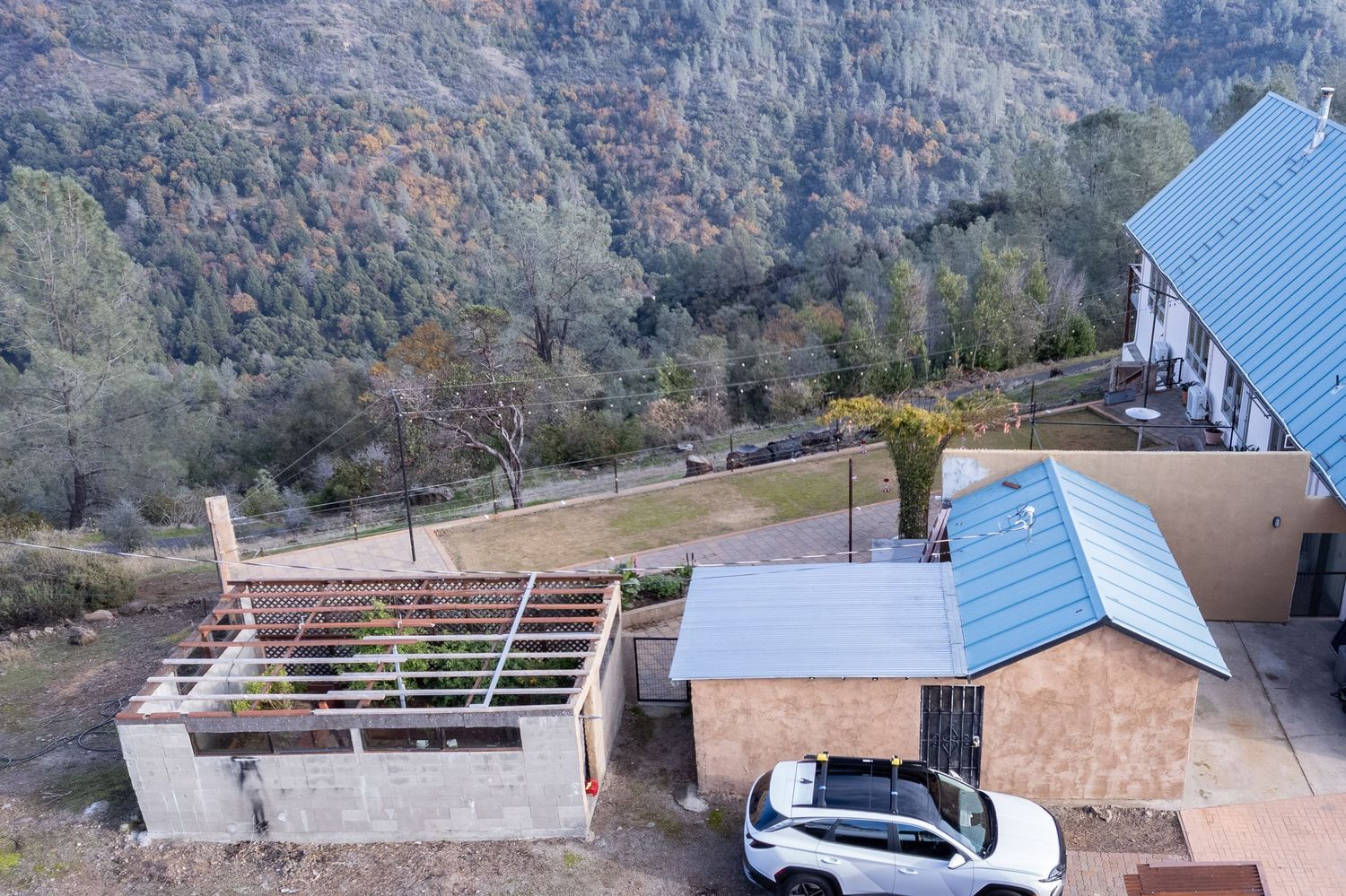 Elevated aerial of residential metal roof with mountain backdrop Forest Ranch,California. Elevated drone shot