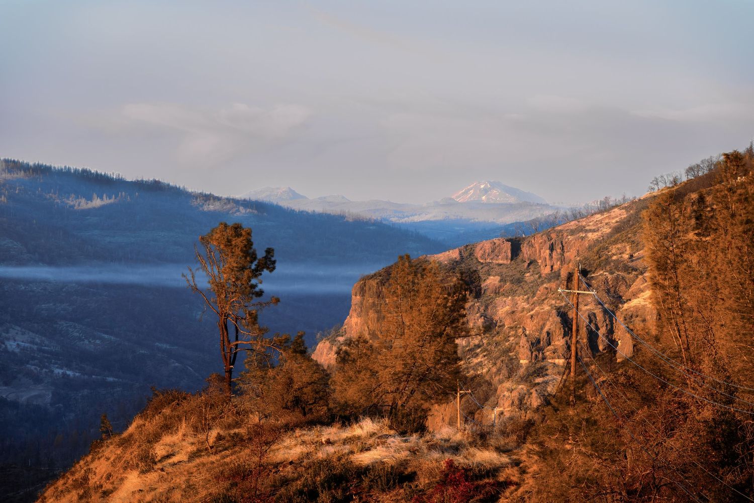 Sunset landscape photograph from Crown Point Forest Ranch California showing layered mountain ridges, volcanic rock formations, valley fog,