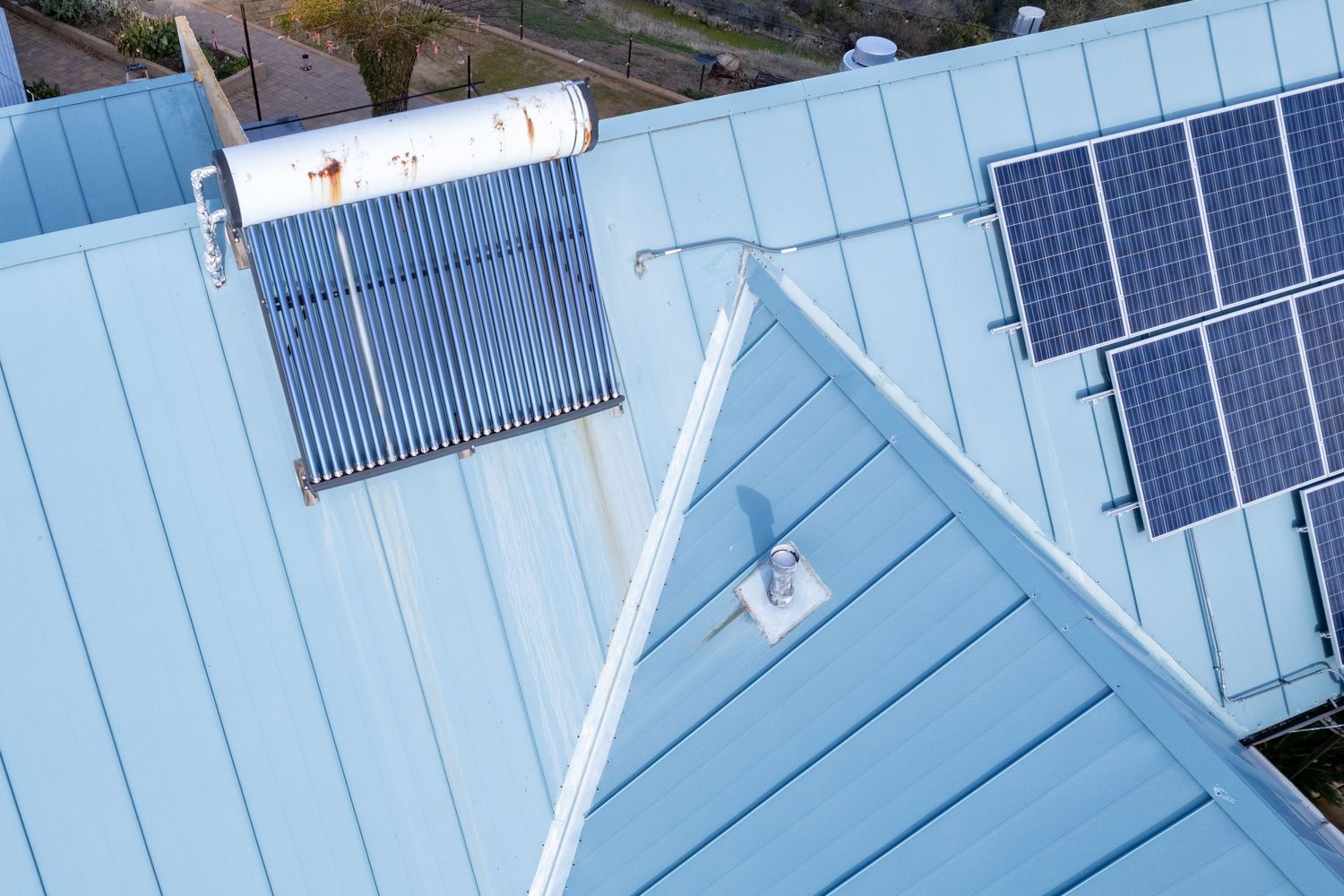 Close-up drone image of roof vent penetration and metal panel seams, Forest Ranch. Elevated drone shot