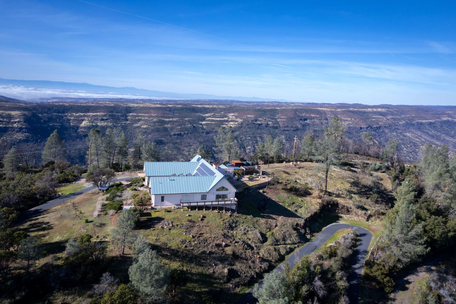 Aerial drone property survey of Forest Ranch property showing the east side of the house. Elevated. mountians in the background