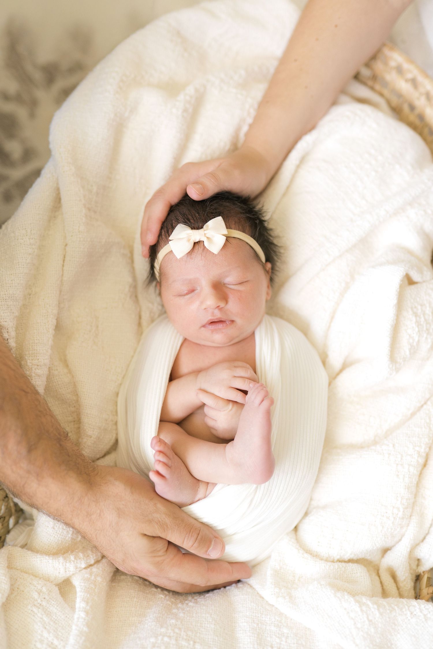 Newborn baby resting in parents’ arms during an in-home session in Northwest Indiana.