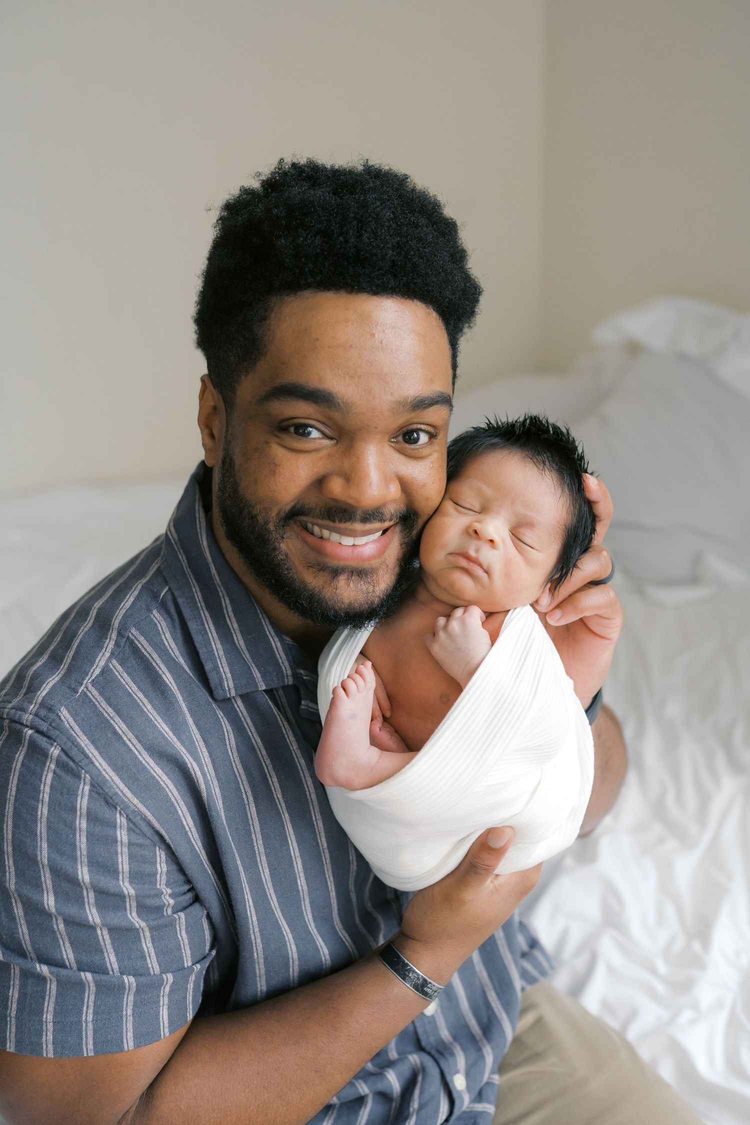 New father holding his newborn baby during an intimate studio newborn session in Valparaiso, Indiana.