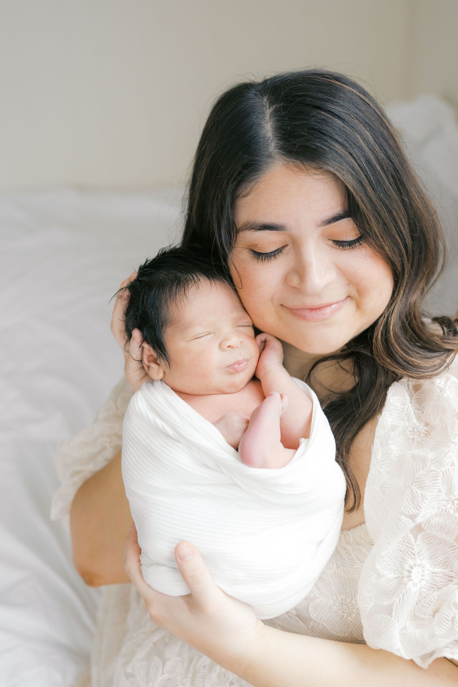 New mother holding her newborn baby during an intimate studio newborn session in Valparaiso, Indiana.