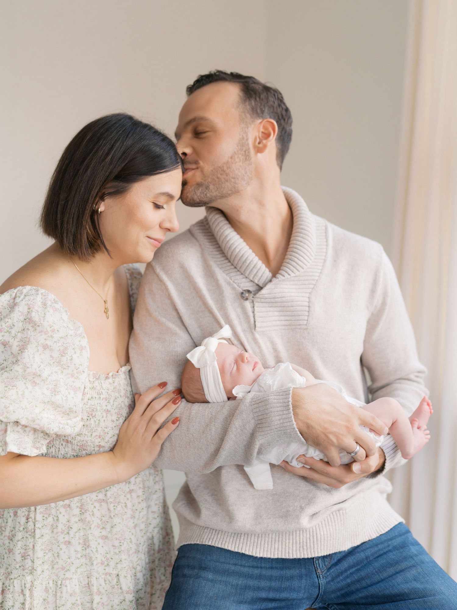 New parents with their first born during a natural light studio session in Valparaiso Indiana