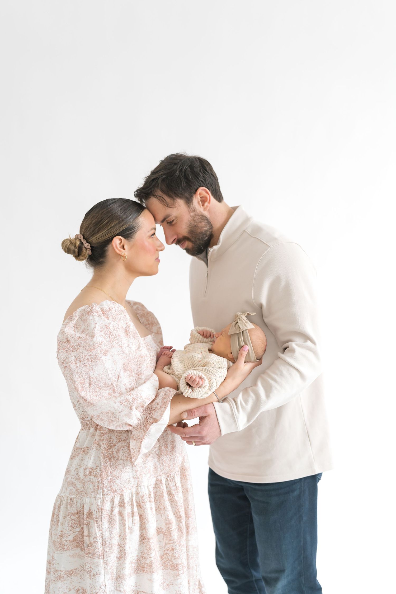mom and dad holding baby during a newborn studio session in downtown Valparaiso indiana
