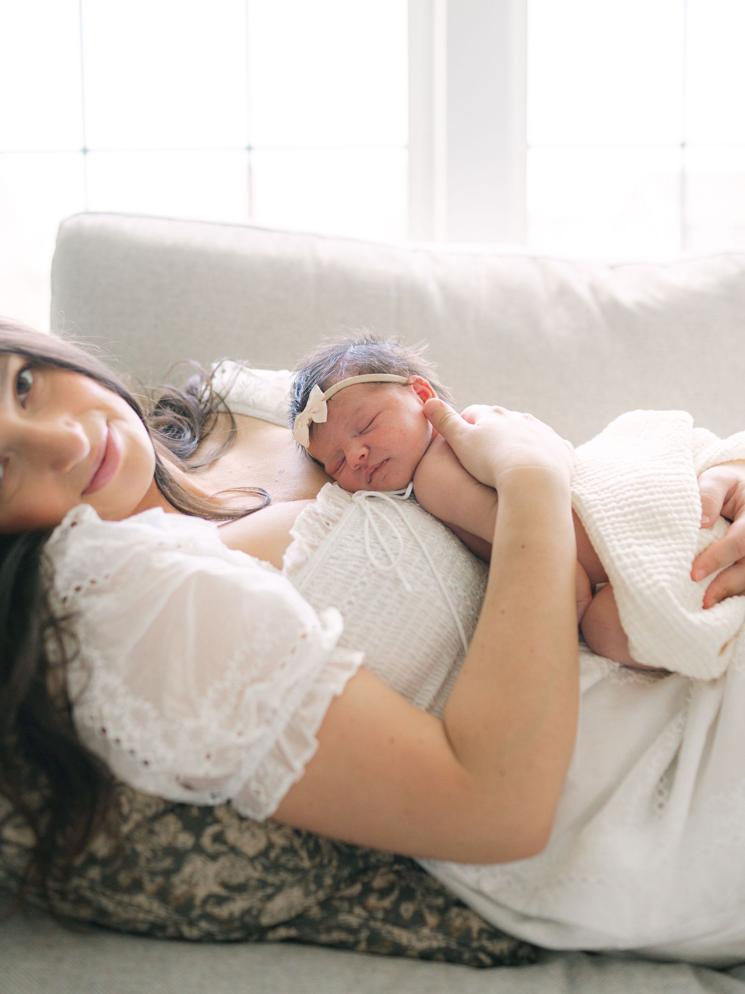 New parents cuddling their newborn in a cozy at-home session in Valparaiso, Indiana.