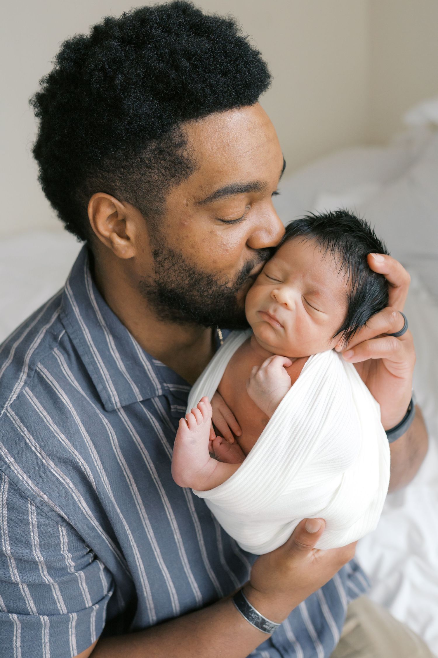 New father holding his newborn baby during an intimate studio newborn session in Valparaiso, Indiana.