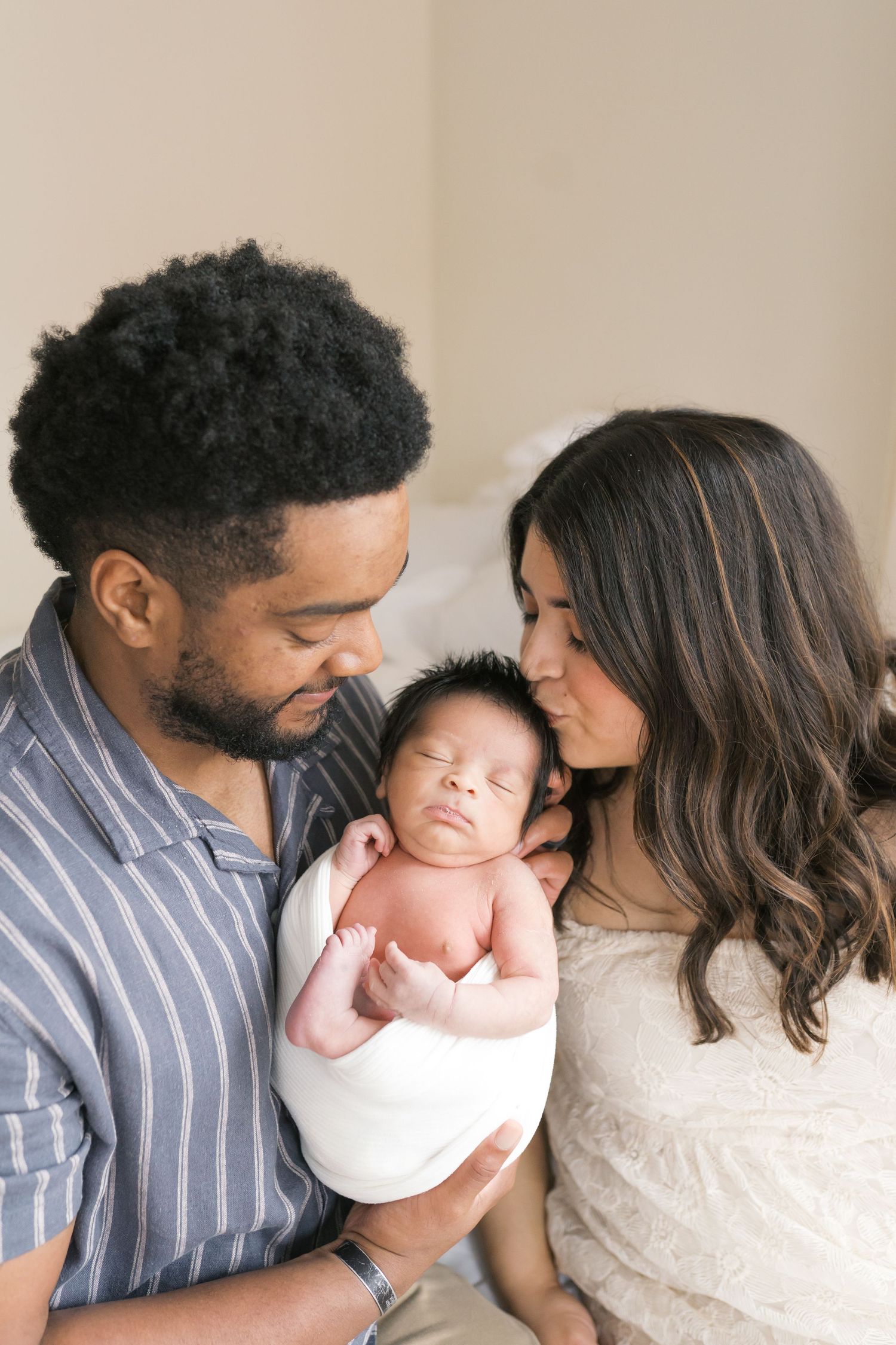 New parents holding their newborn baby during an intimate studio newborn session in Valparaiso, Indiana.