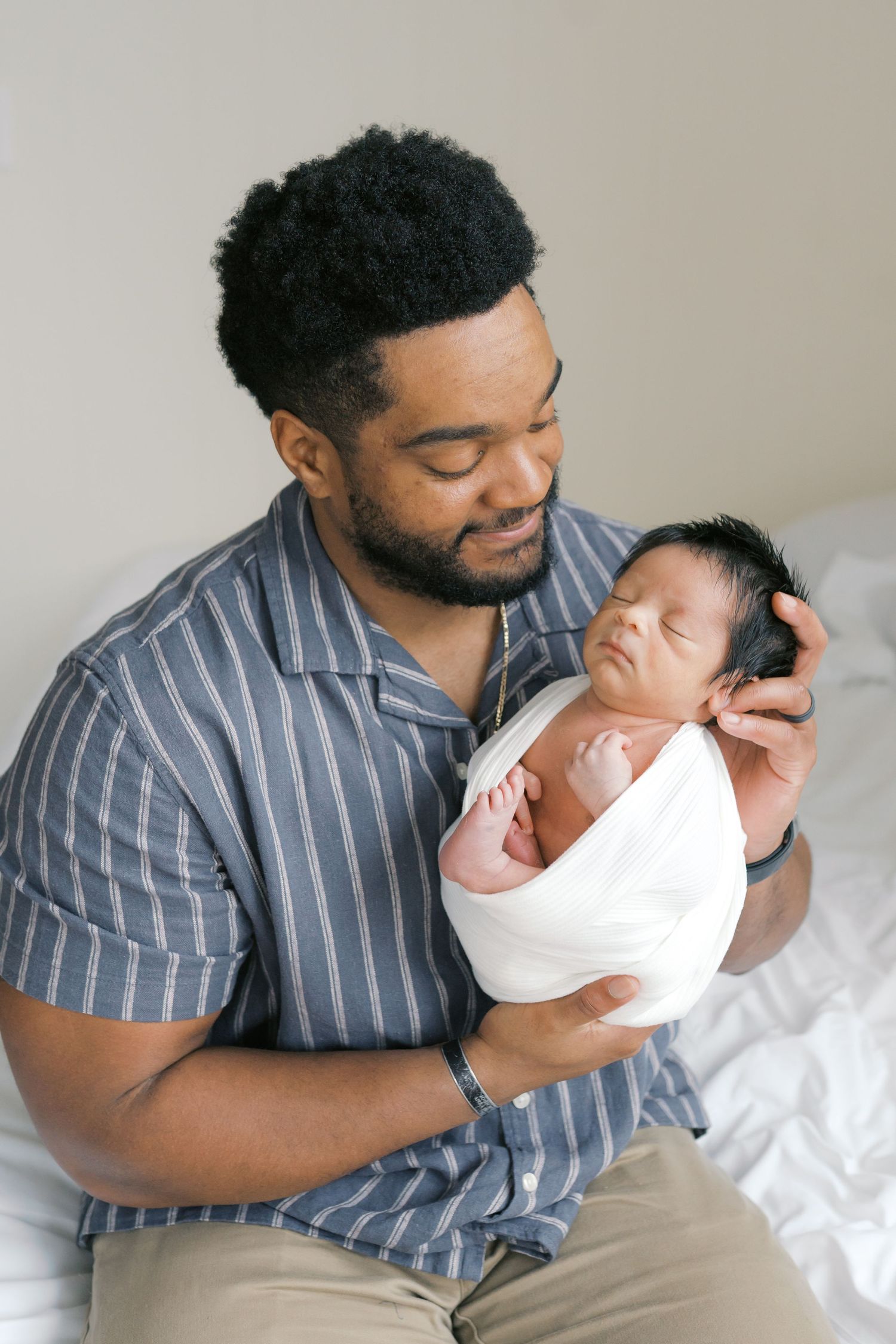 New father holding his newborn baby during an intimate studio newborn session in Valparaiso, Indiana.