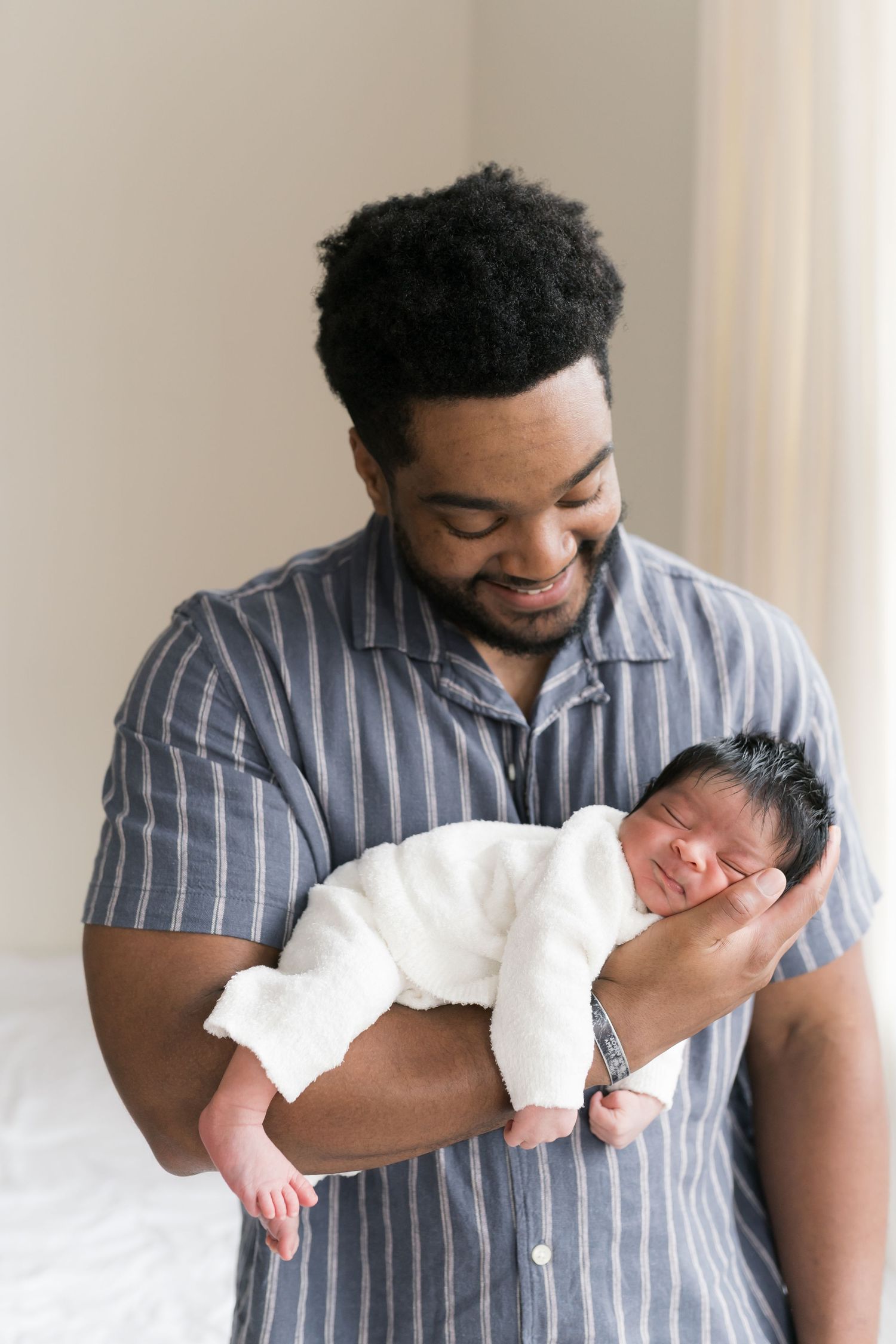 Newborn baby and dad during a minimalist newborn studio session near Chicago area located in Valparaiso Indiana