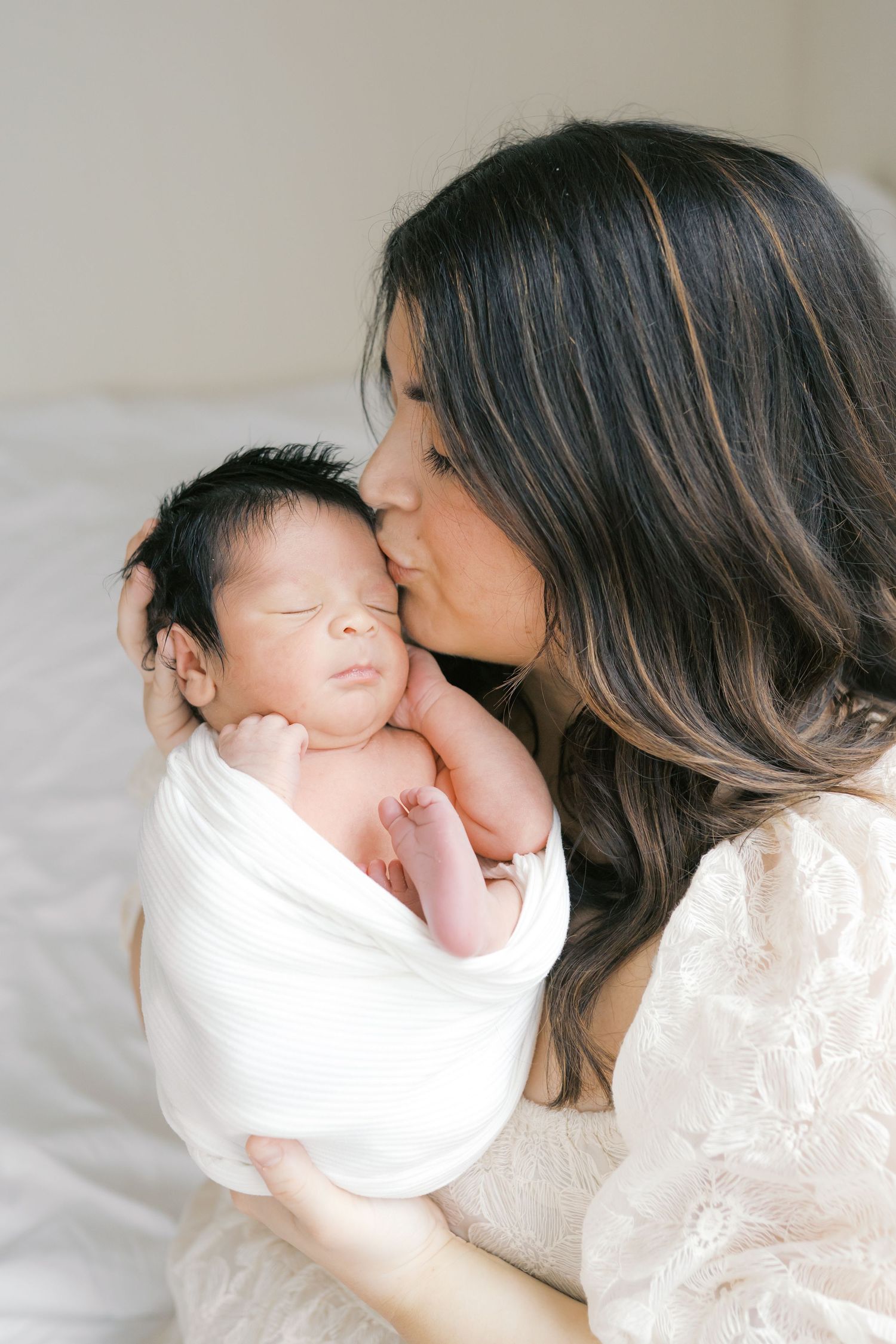 New mother holding her newborn baby during an intimate studio newborn session in Valparaiso, Indiana.