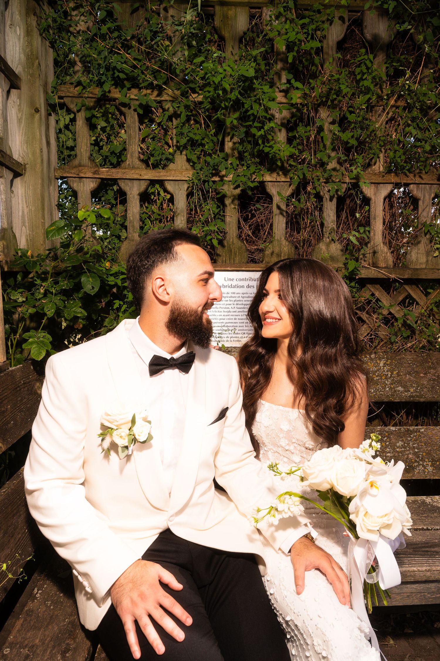 Intimate wedding couple portrait session on rustic wooden bench.