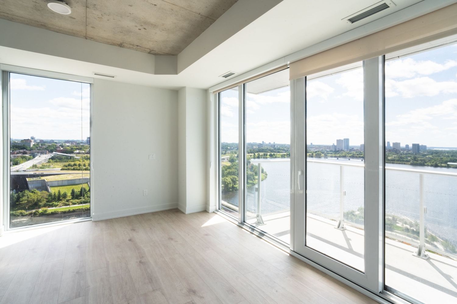 Luxurious apartment space with floor-to-ceiling windows overlooking waterfront views.