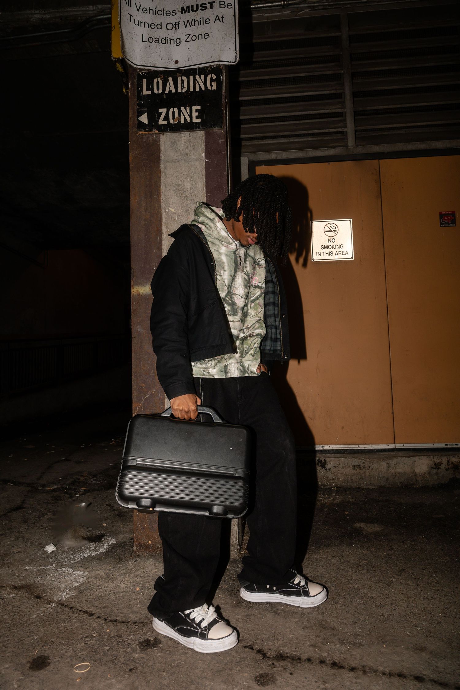 Loading zone fashion shoot featuring camouflage and black streetwear ensemble.