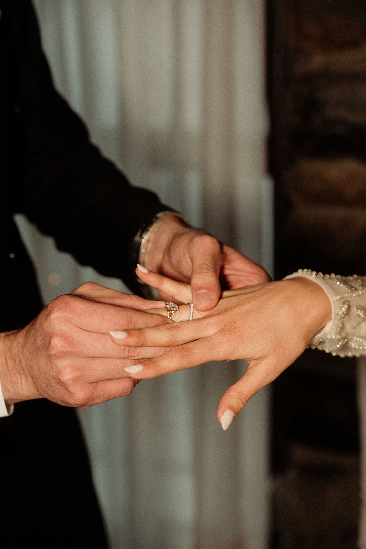 Close-up shot of a ring being placed on a finger during a wedding ceremony.