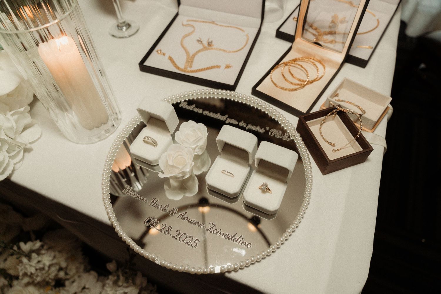 Close-up of elegant wedding rings displayed on a textured white surface with decorative elements.