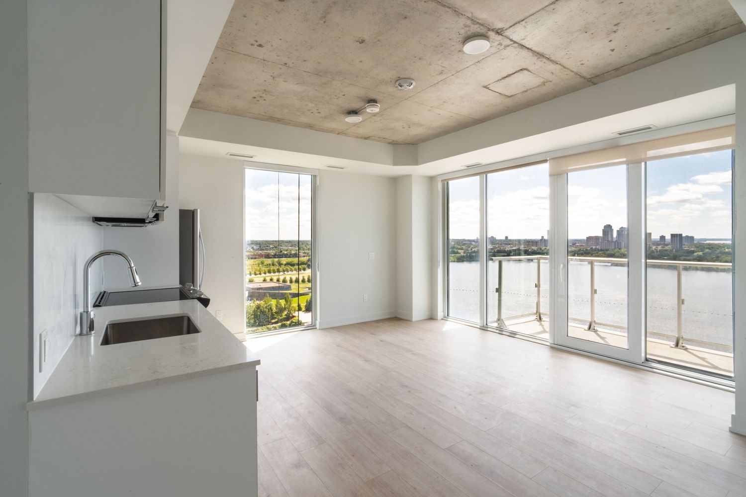 Open concept room with concrete ceiling and floor-to-ceiling windows offering panoramic views.