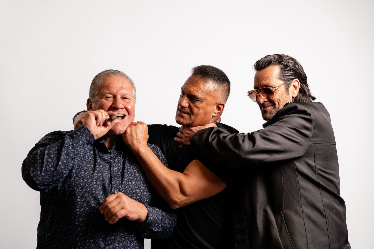 Group of people in casual attire playfully interacting in studio setting.