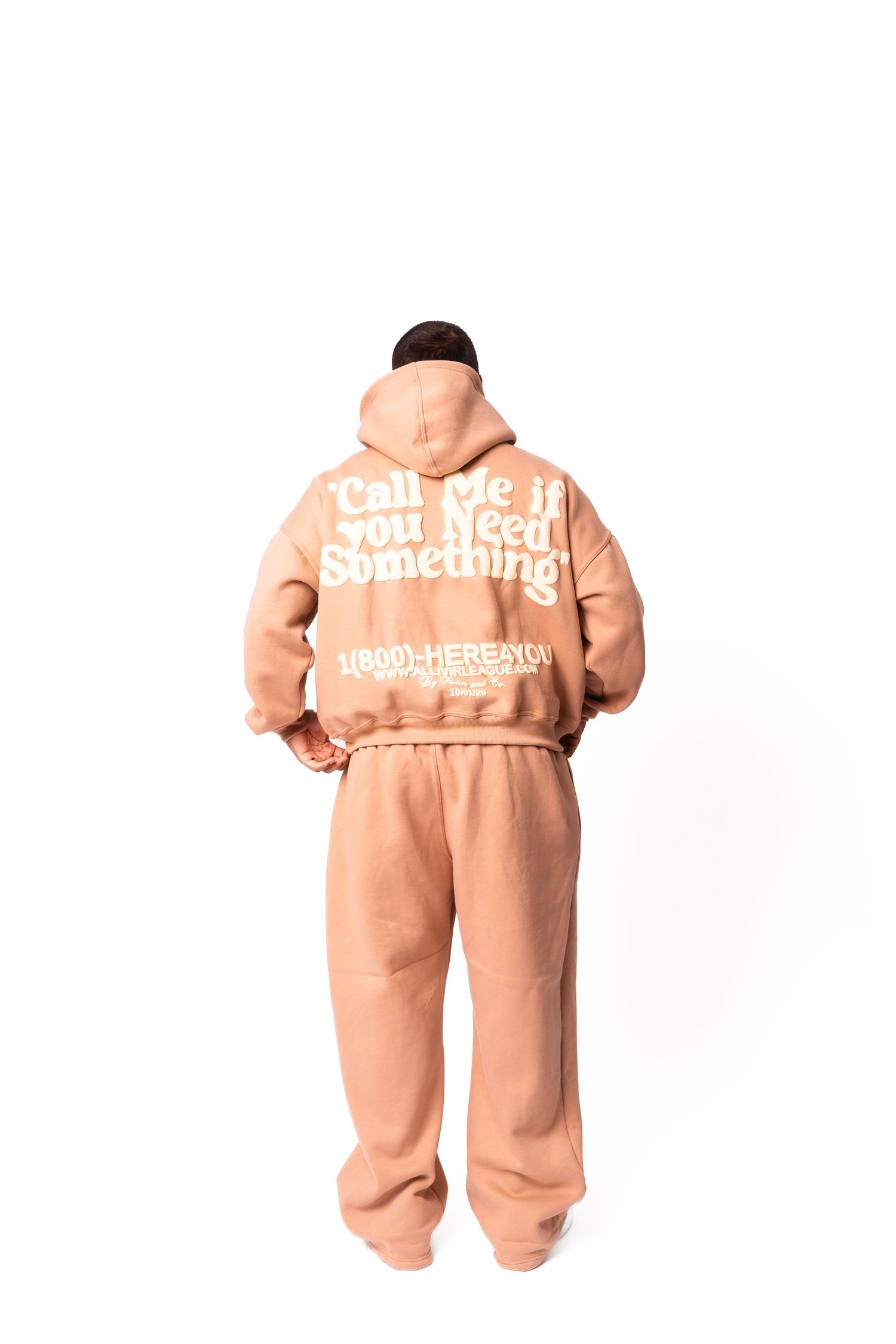 Back view of person in peach sweatsuit with text design.