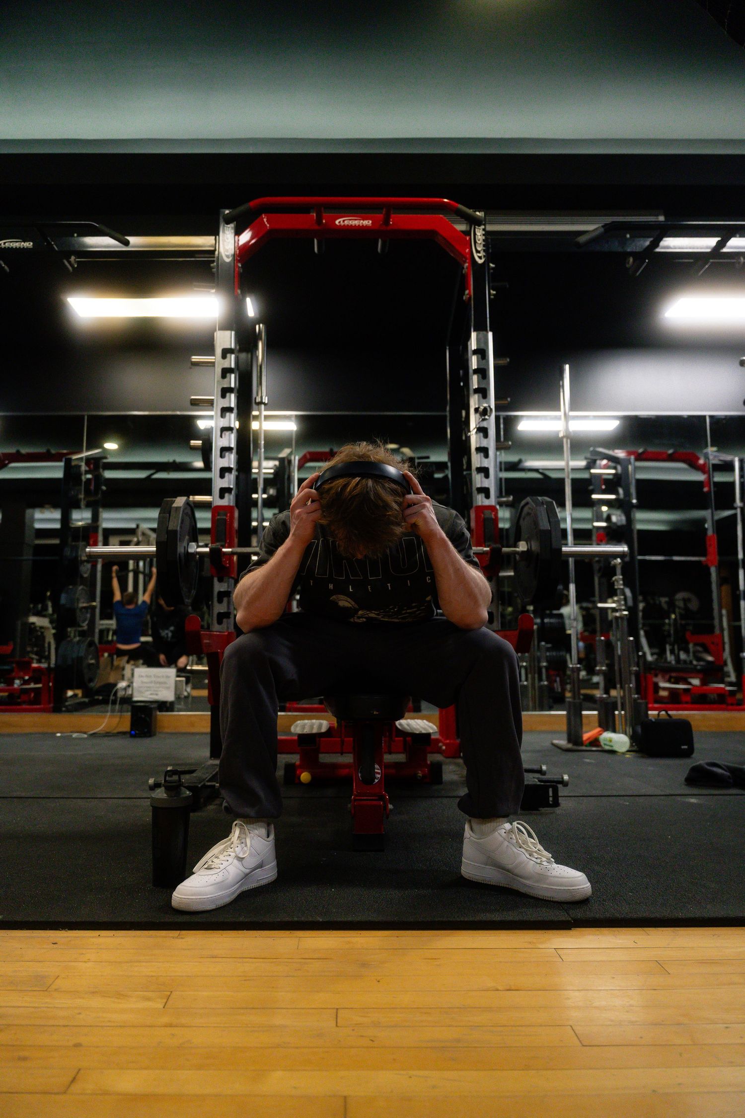 Low angle shot of weight training equipment in a dimly lit modern gym facility.