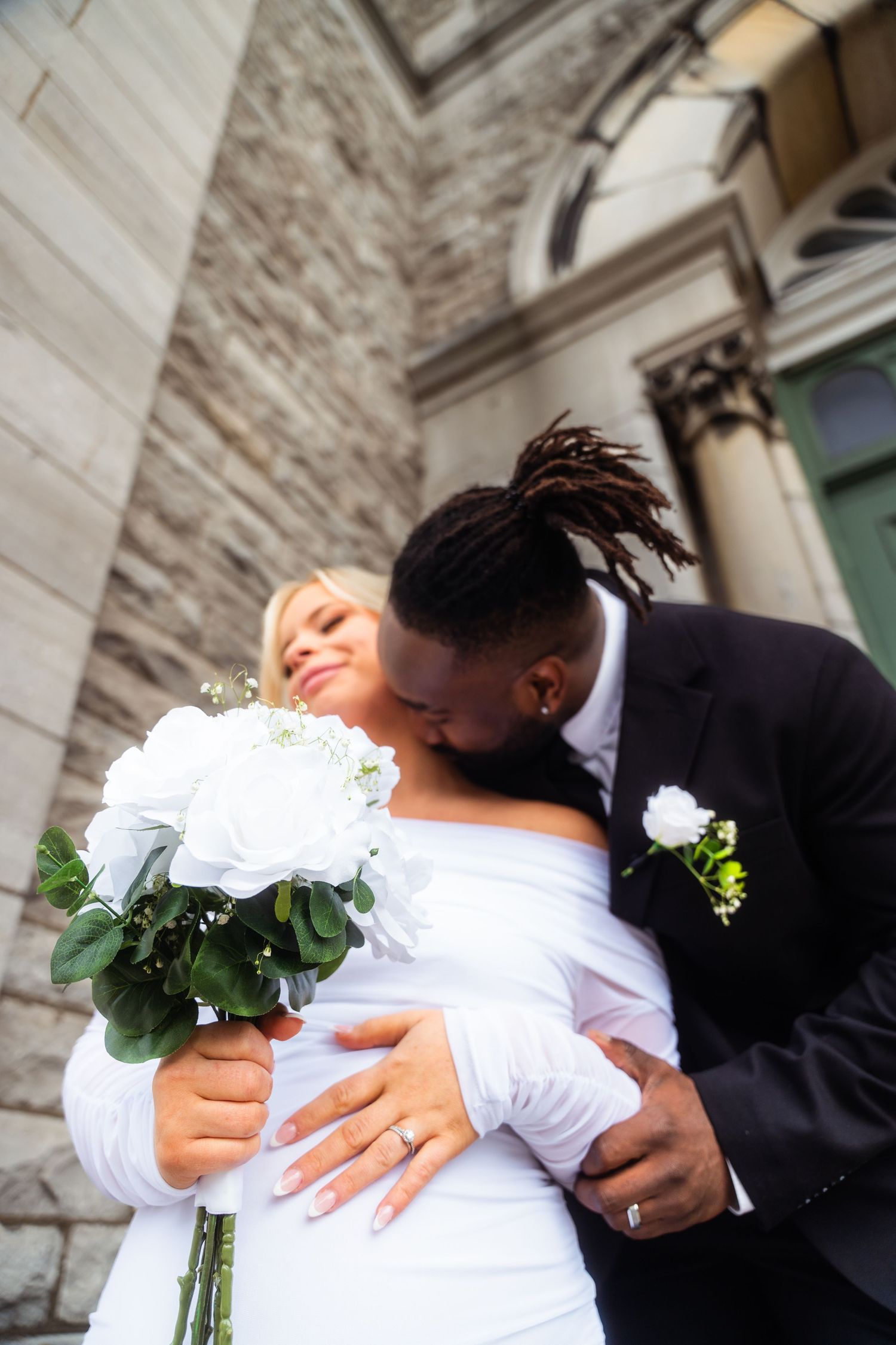 Wedding photo series showing intimate embraces with white bouquet details.
