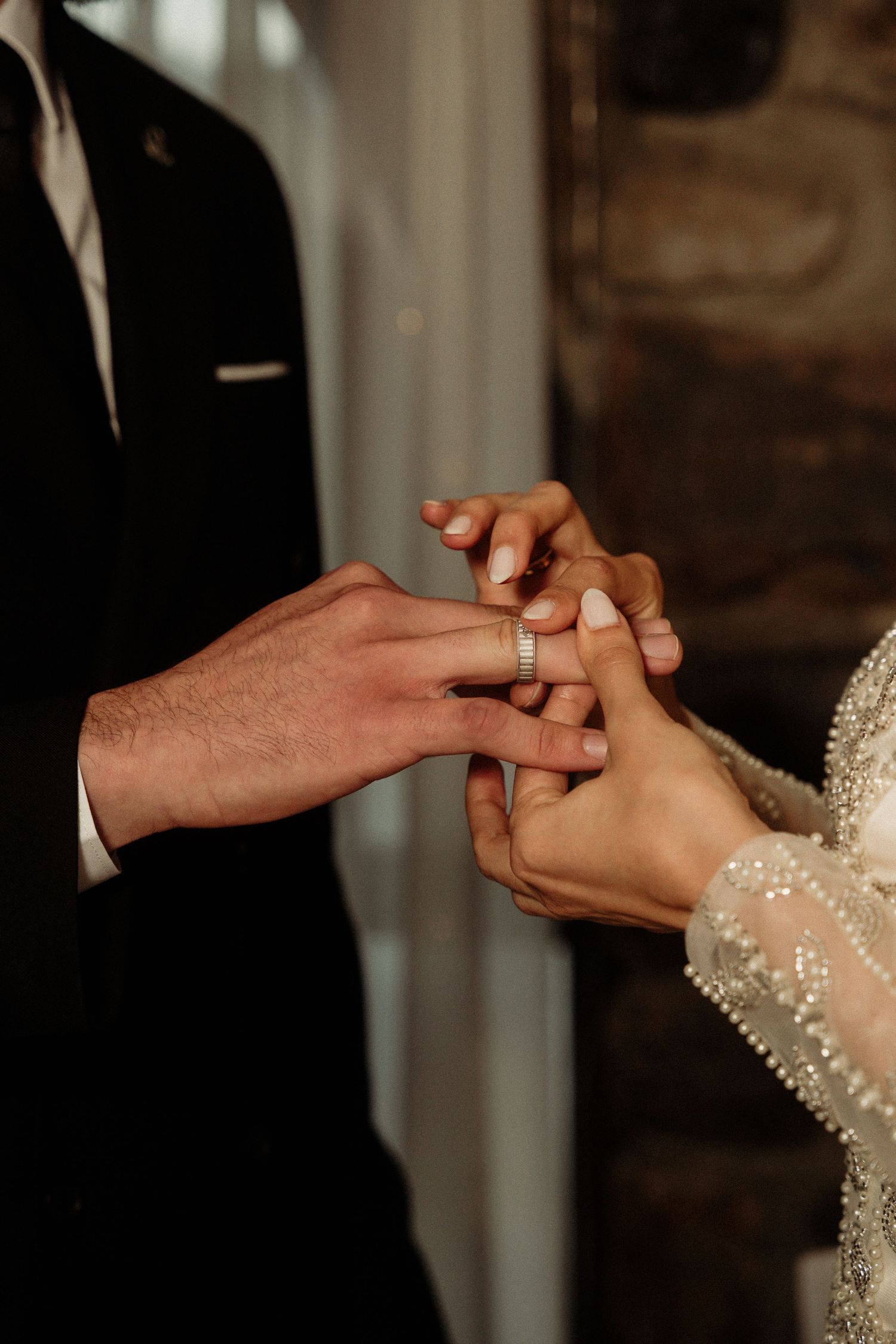 Close-up sequence of hands exchanging wedding rings during a marriage ceremony.