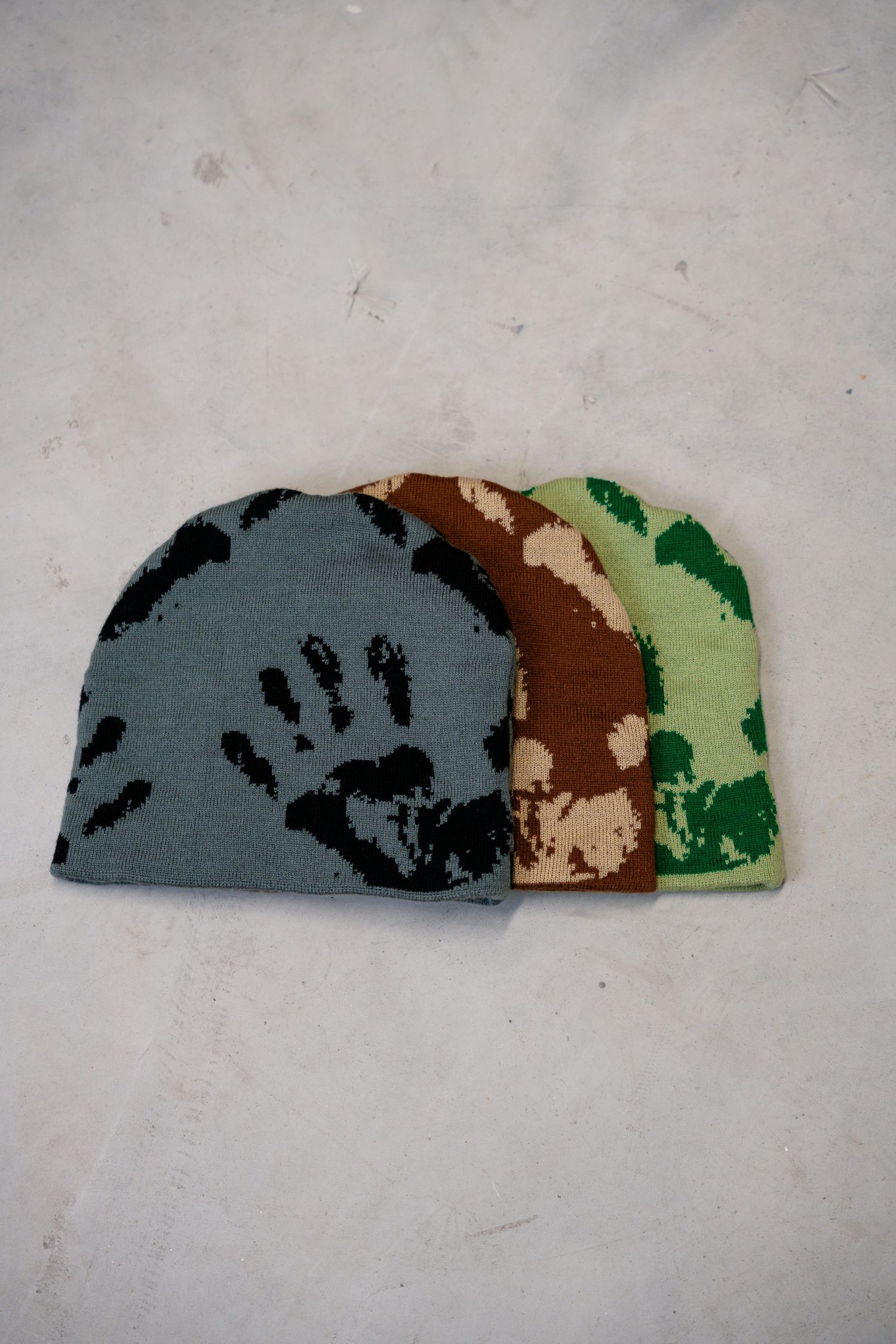 Sequence showing a camouflage pattern design in gray, brown and green colors on a light background.