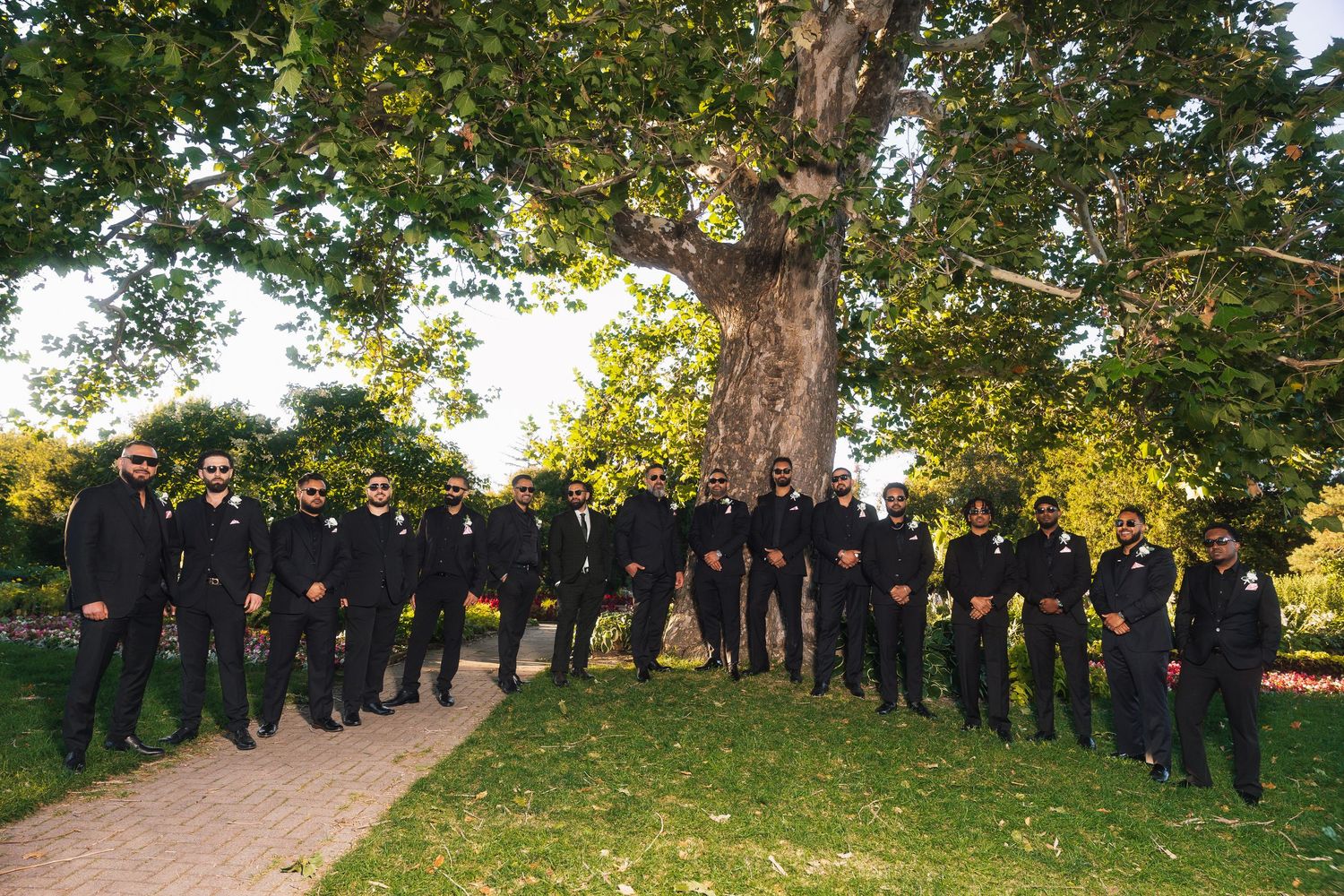 A panoramic view of people standing in a line formation among trees during an outdoor gathering.