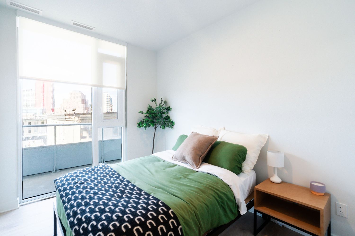 Cozy bedroom with green accents featuring a comfortable bed and natural lighting.
