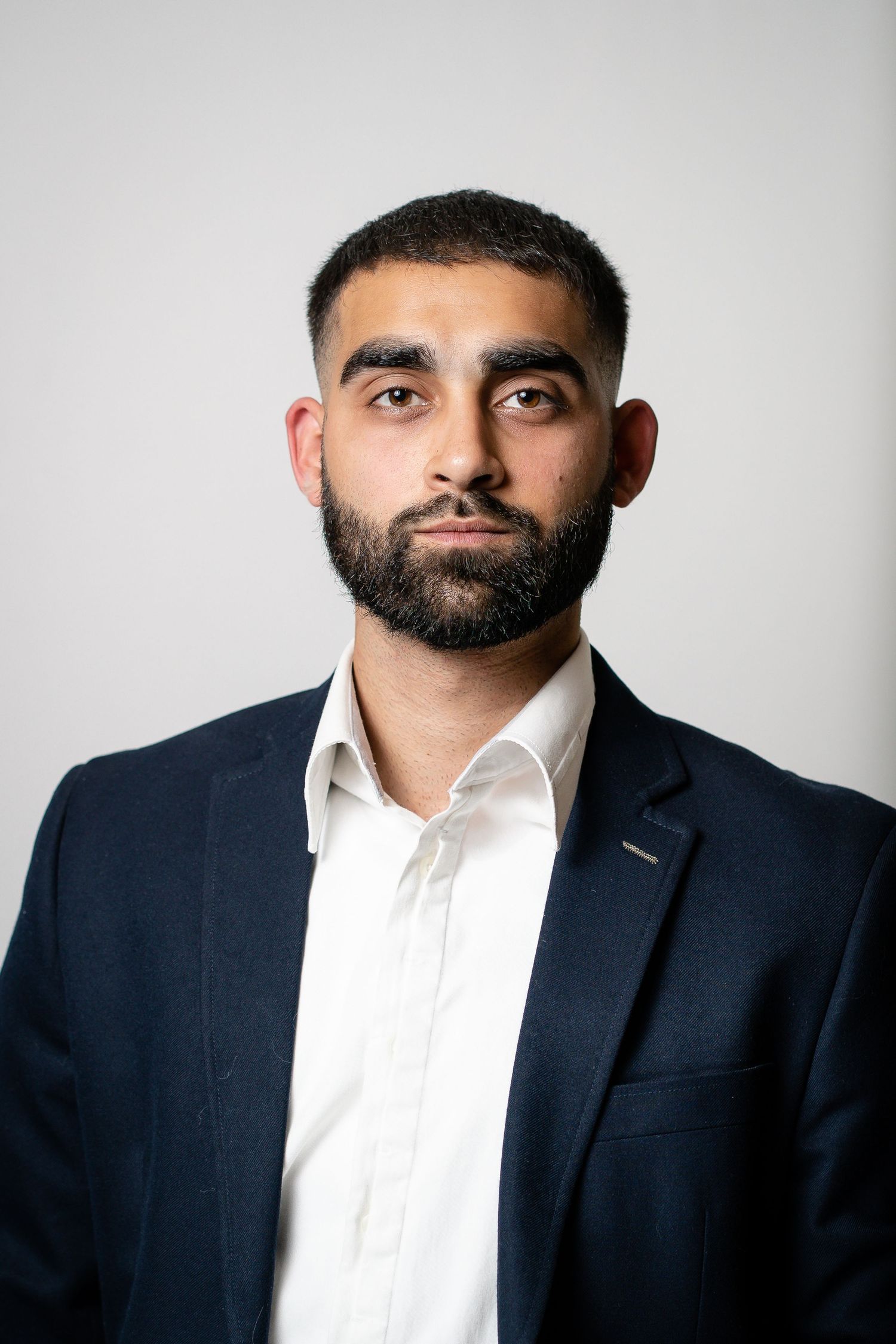 Professional headshots showing different angles in business attire against light background.