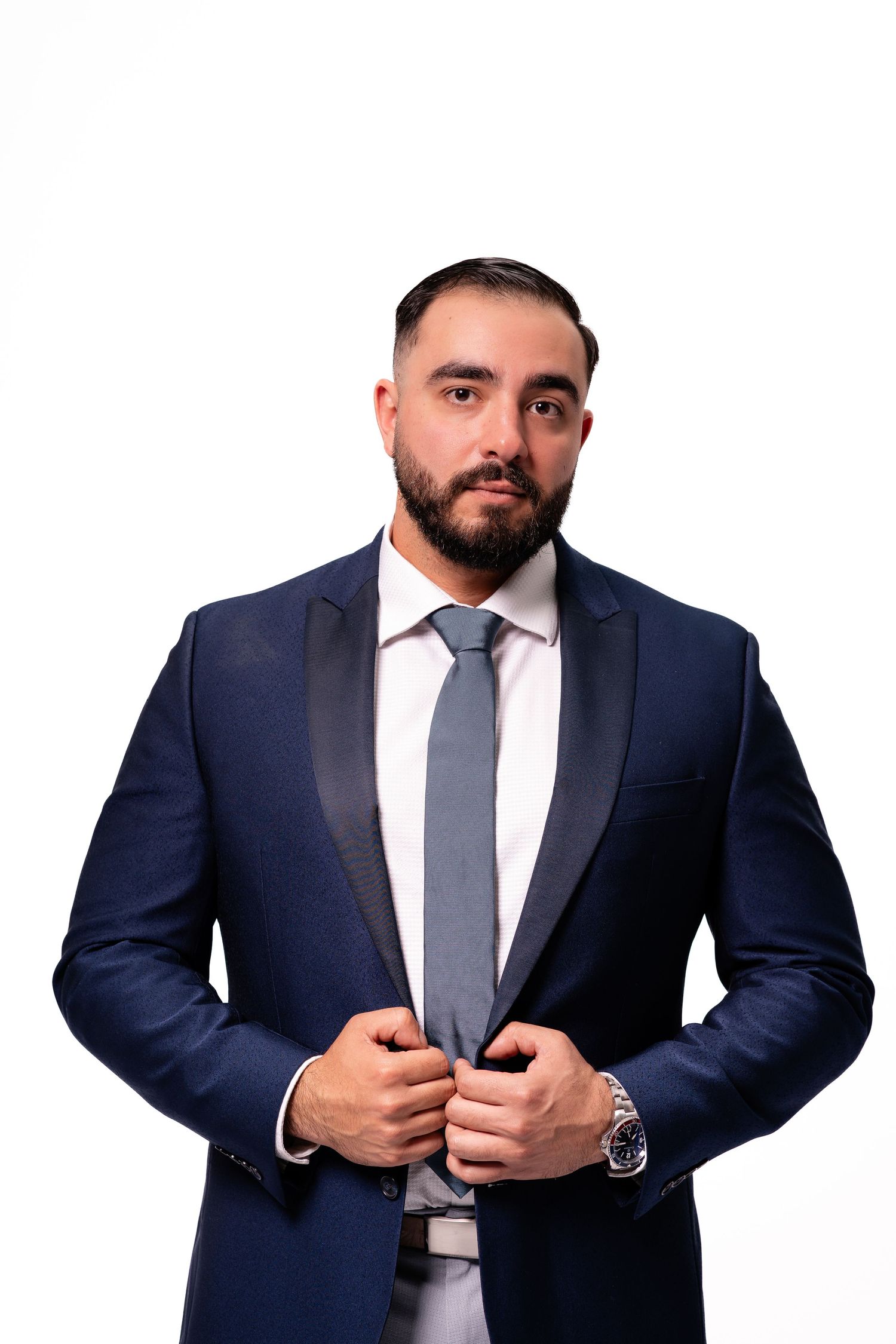 Professional photos of person in navy suit and tie against white backdrop.