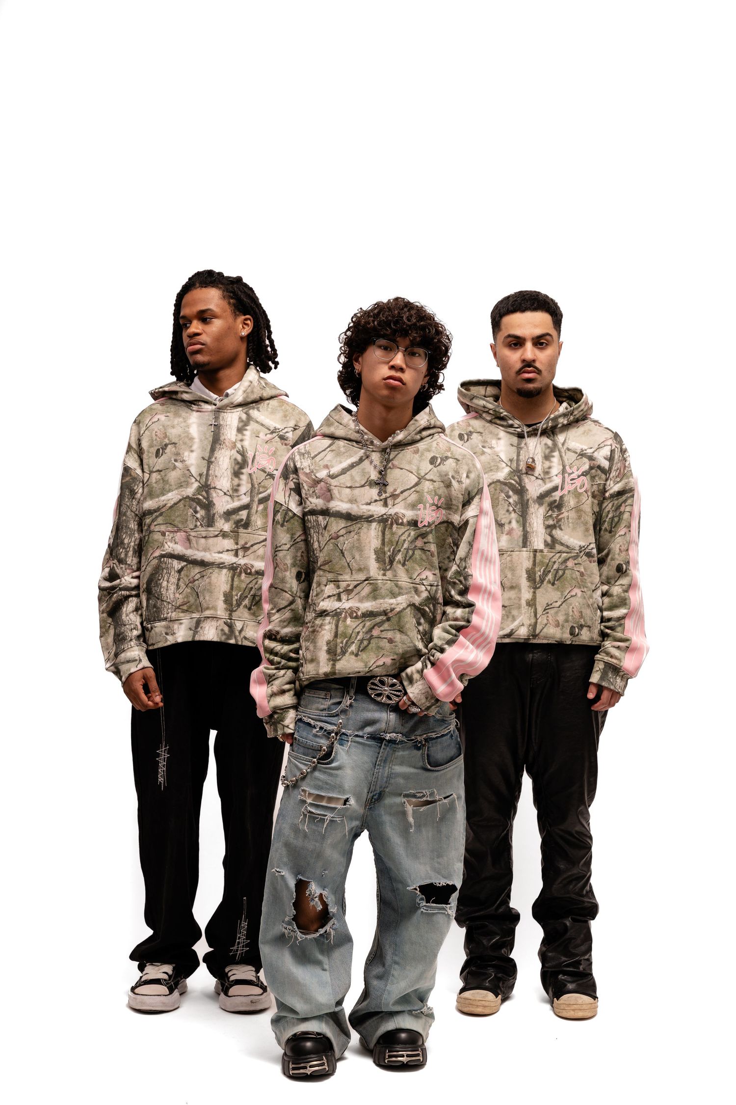 Group wearing matching camo jackets with pink accents in casual streetwear.