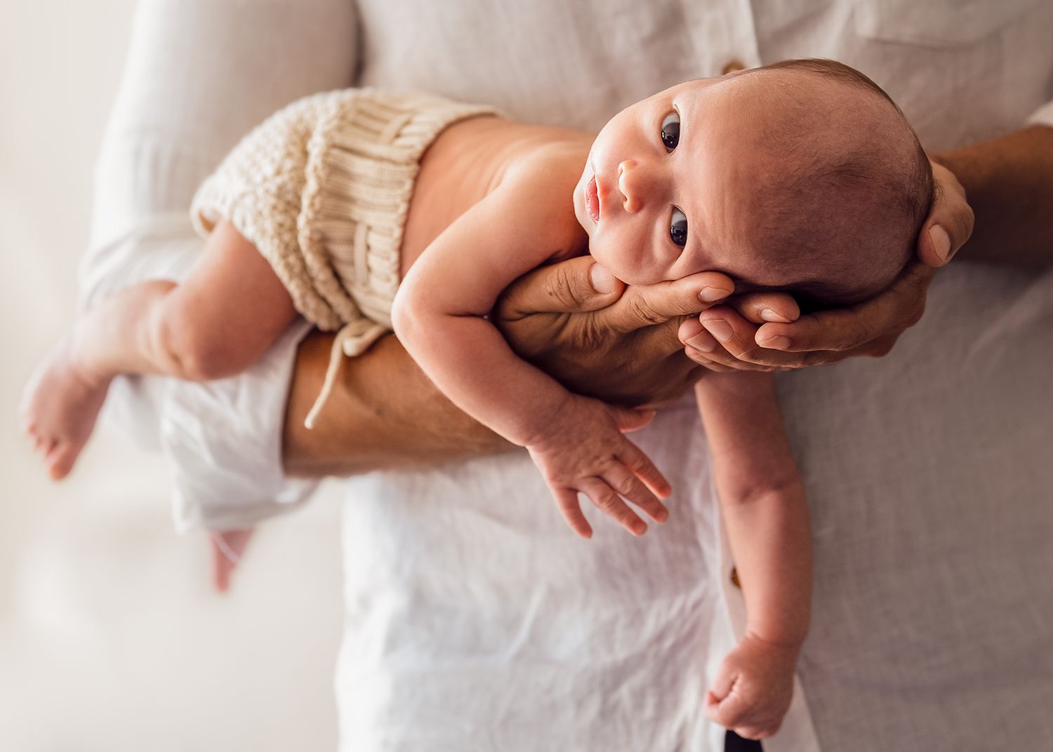 dad-hands-newborn