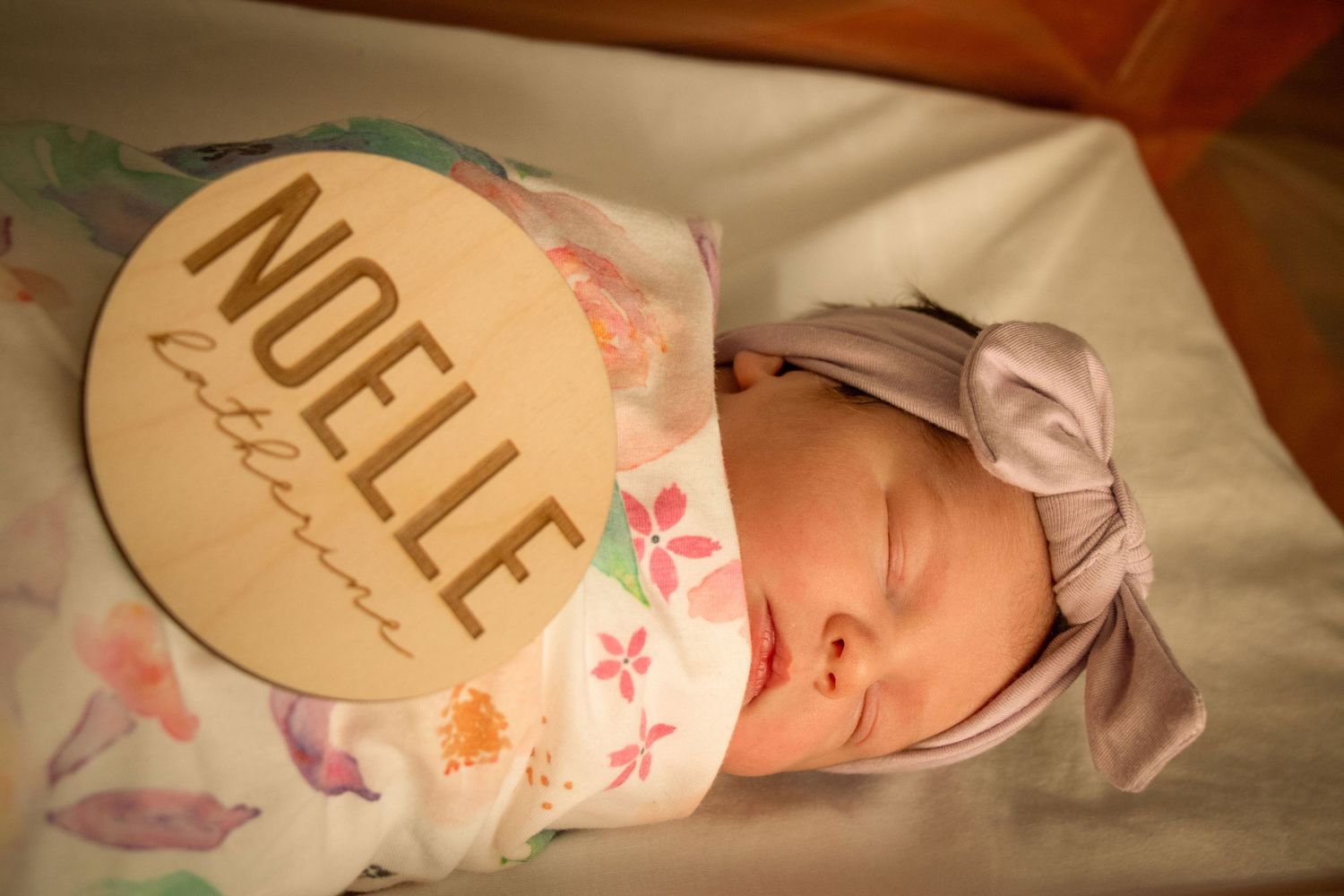 Newborn baby girl with name plaque