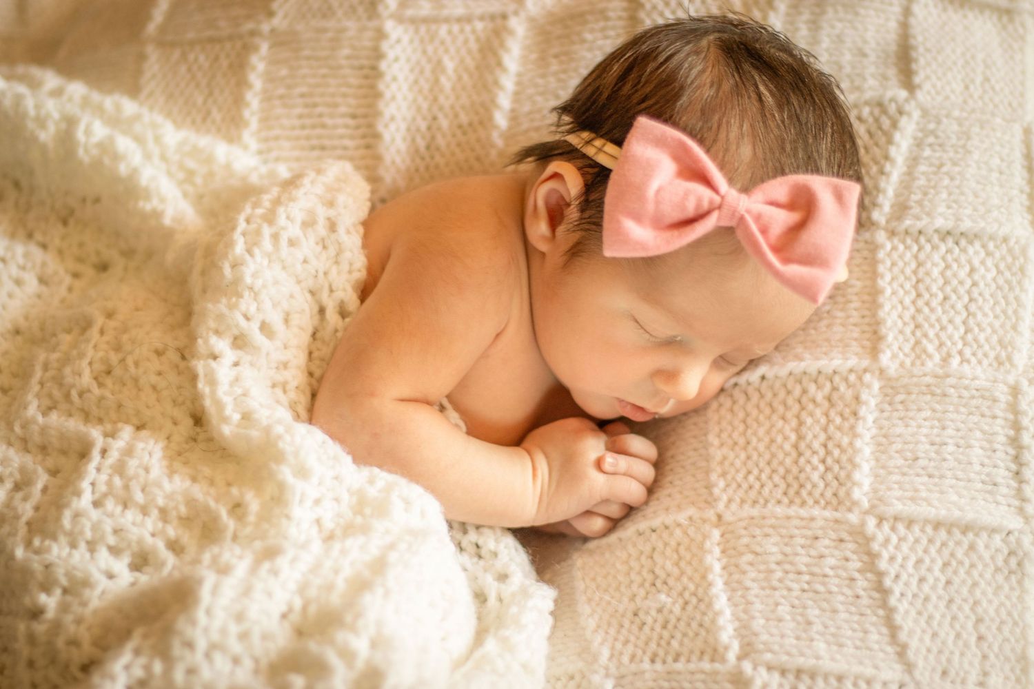 Newborn girl with hands folded