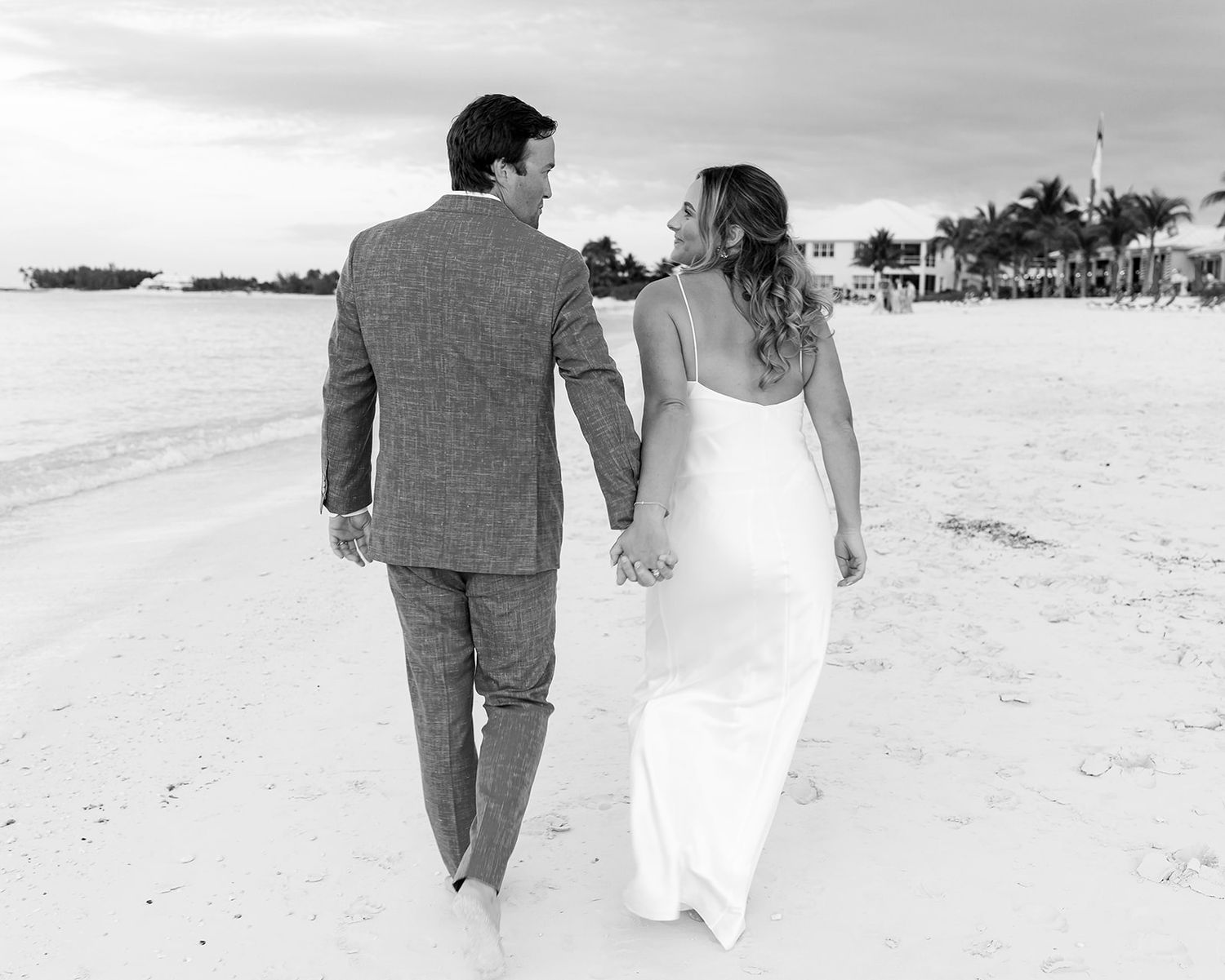 A romantic black and white sequence of a couple walking together on a tropical beach.