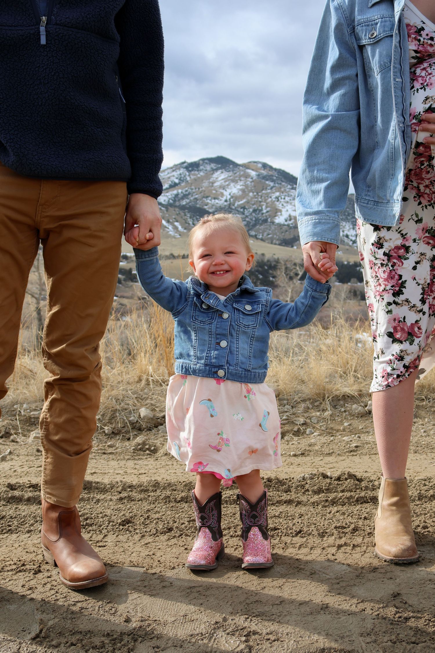 Close-up view of family's feet standing together with mountains in background.