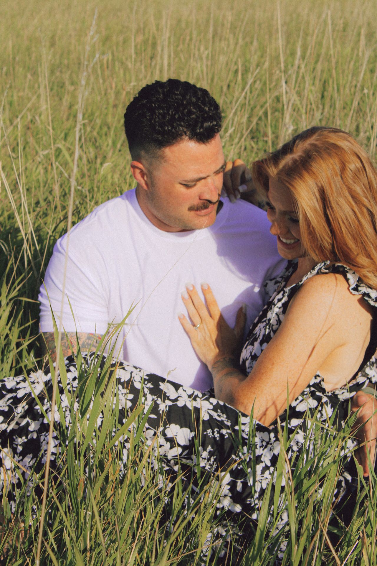 A couple lies together in tall grass wearing matching outfits, captured from different angles in a progressive sequence.