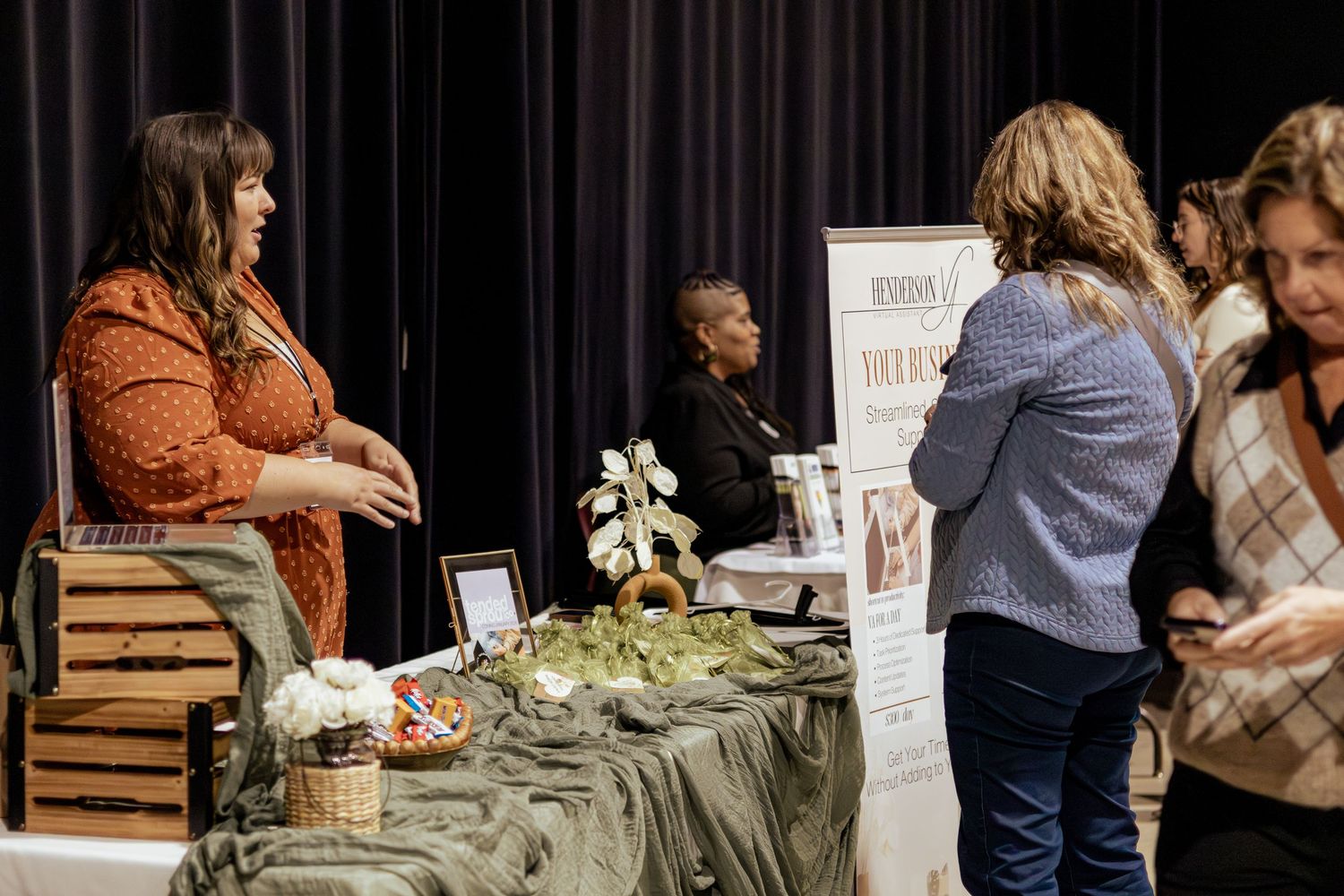People working together at a floral design workshop with fresh flowers and greenery on a table.
